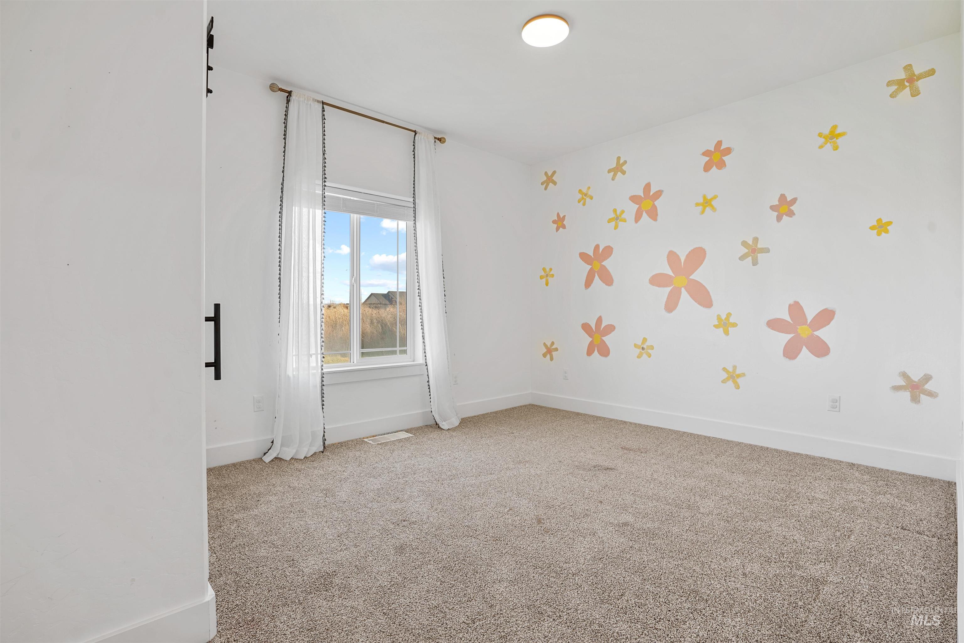 Spare room featuring light colored carpet and baseboards