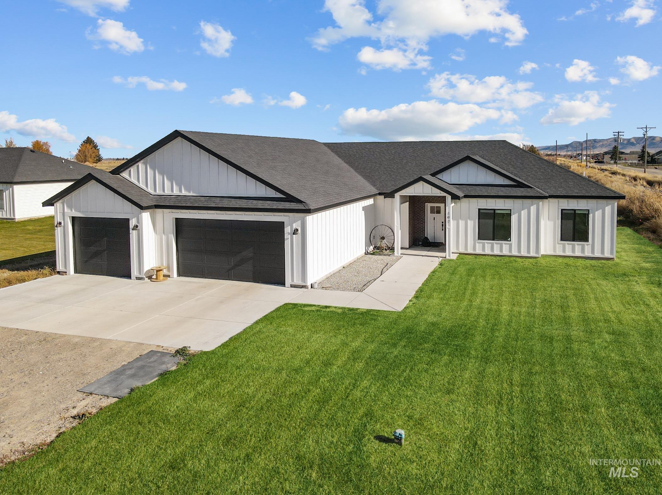 Modern farmhouse style home with driveway, a shingled roof, a front lawn, and an attached garage