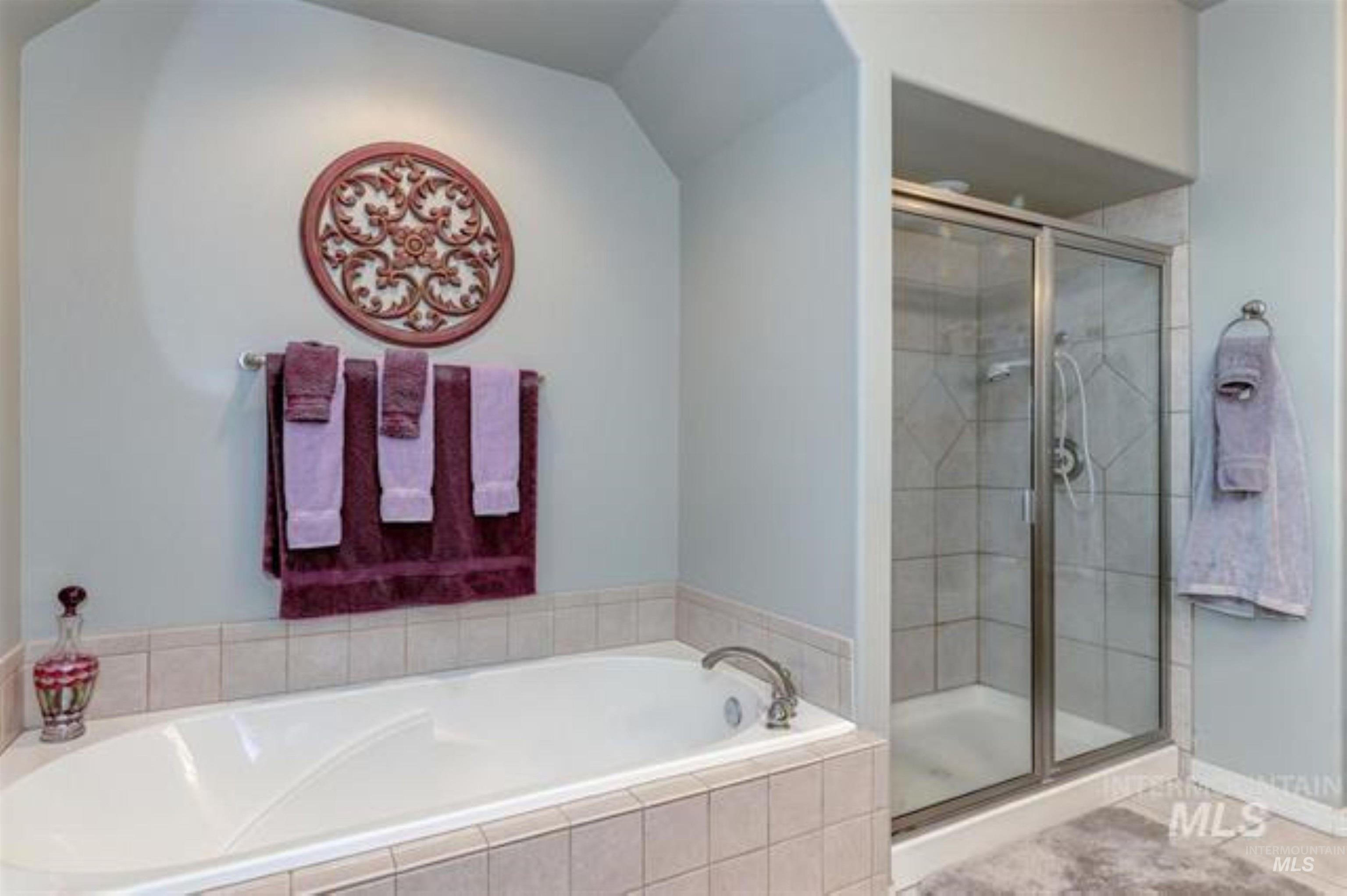 Full bath with a stall shower and a bath