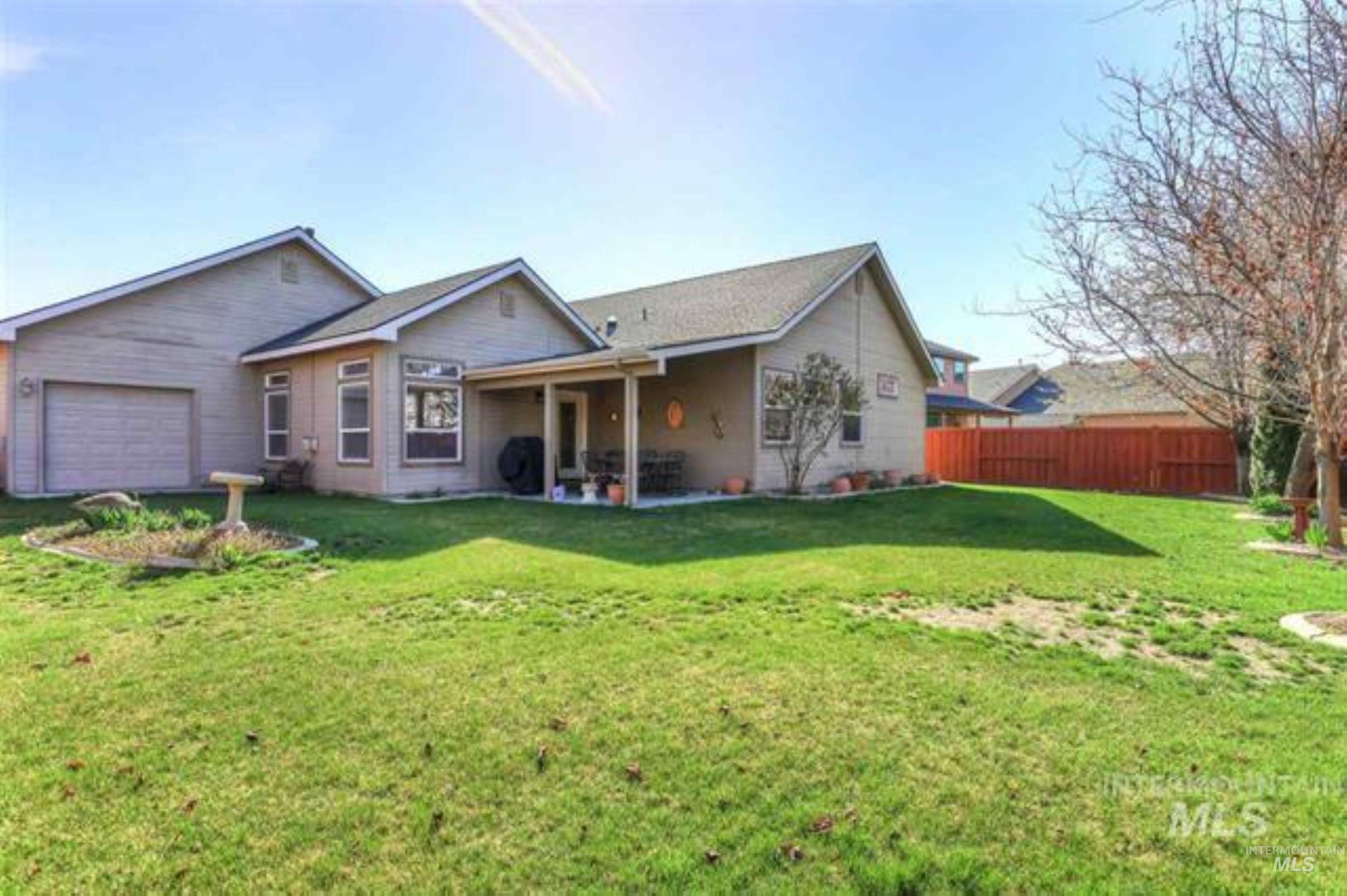 Rear view of property featuring a patio and a garage
