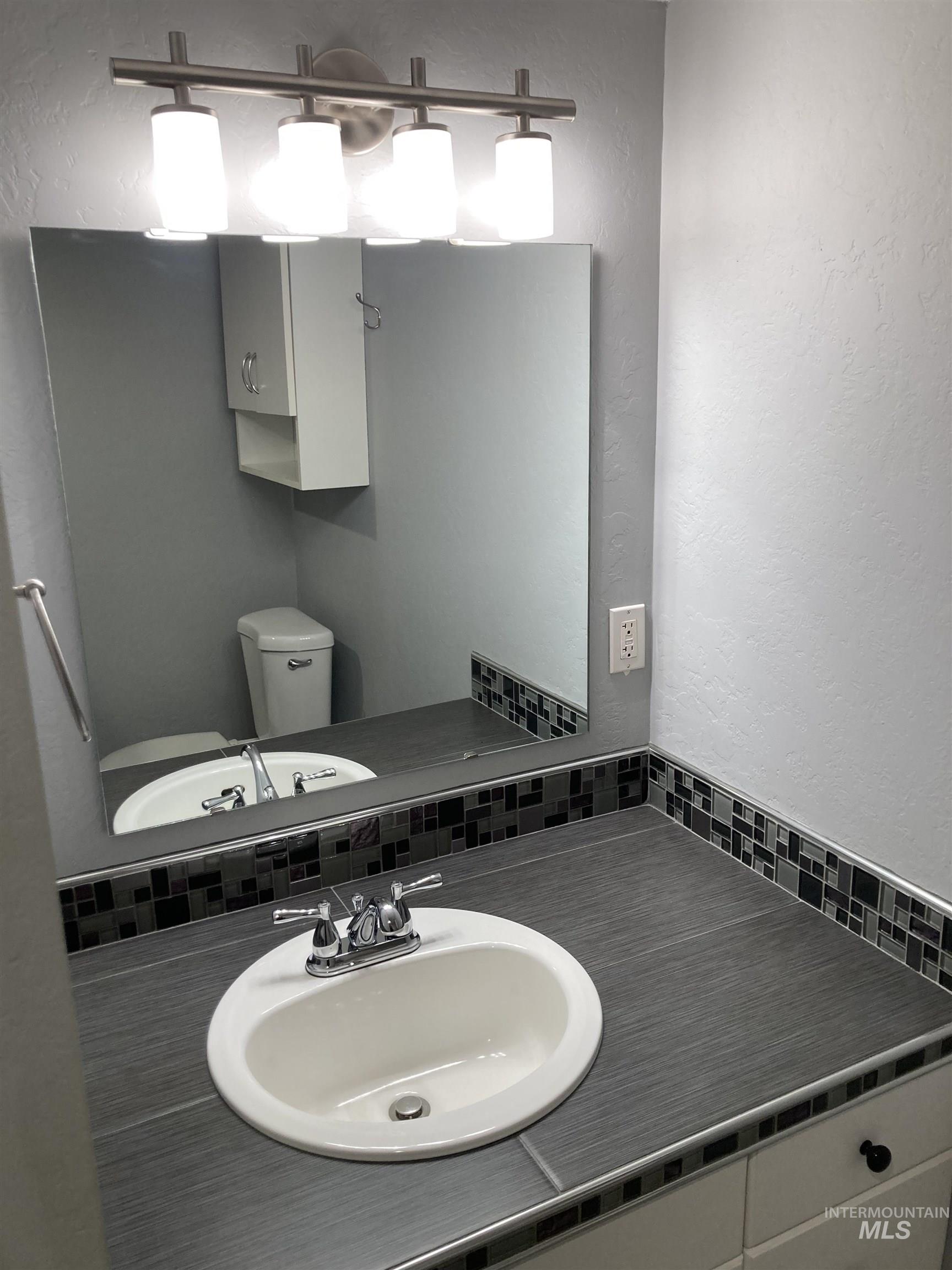 Bathroom with vanity and a textured wall
