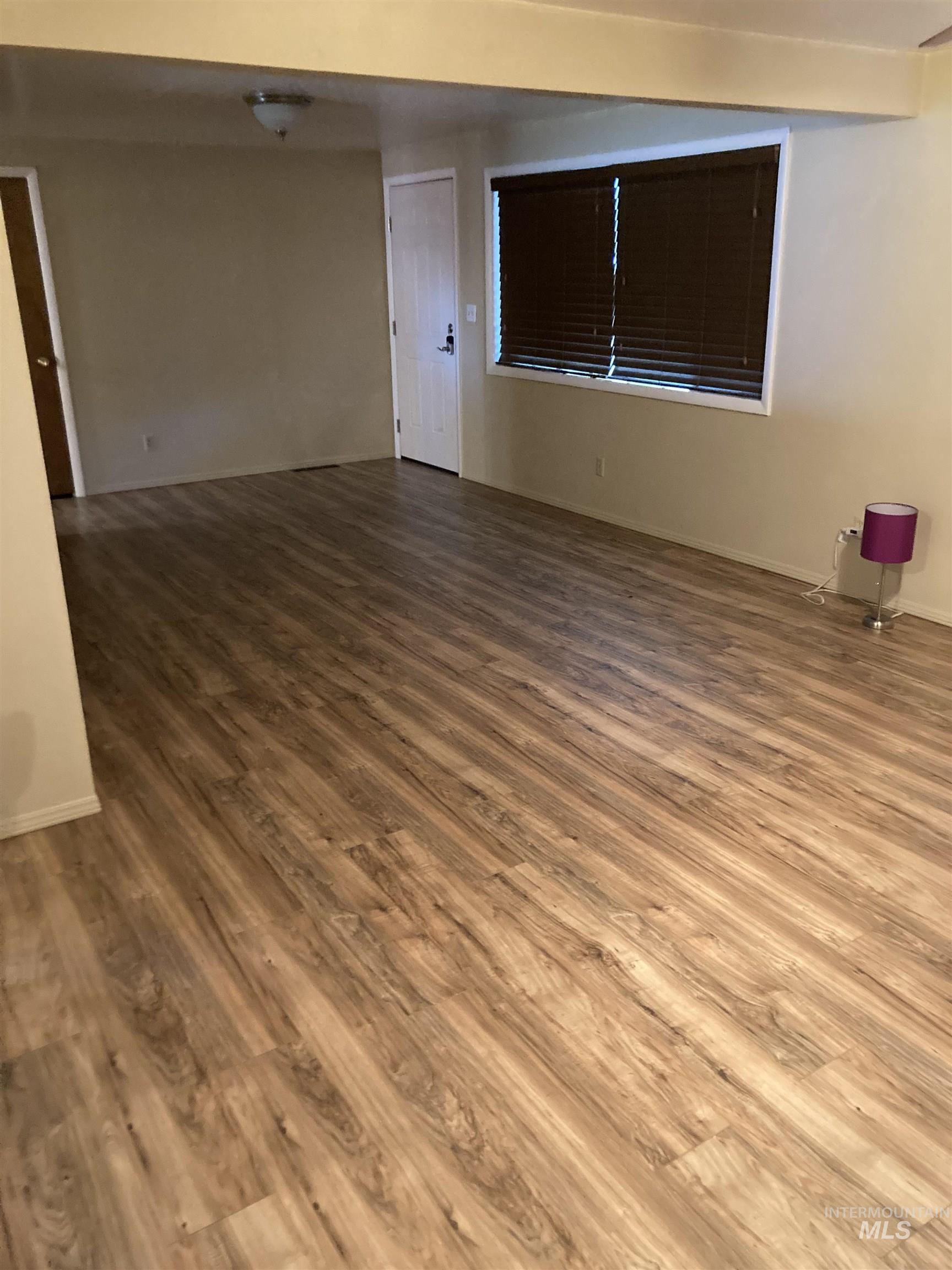 Spare room featuring wood finished floors and baseboards