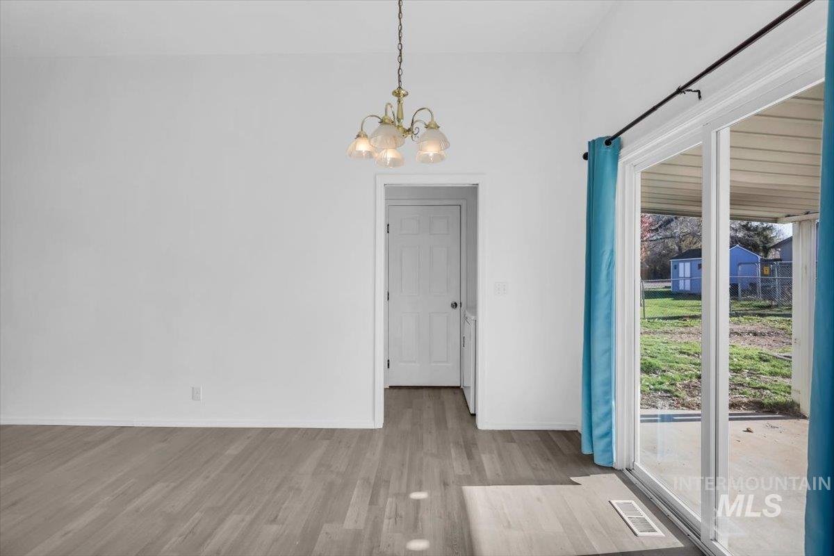 Unfurnished dining area with light wood-style floors and a chandelier