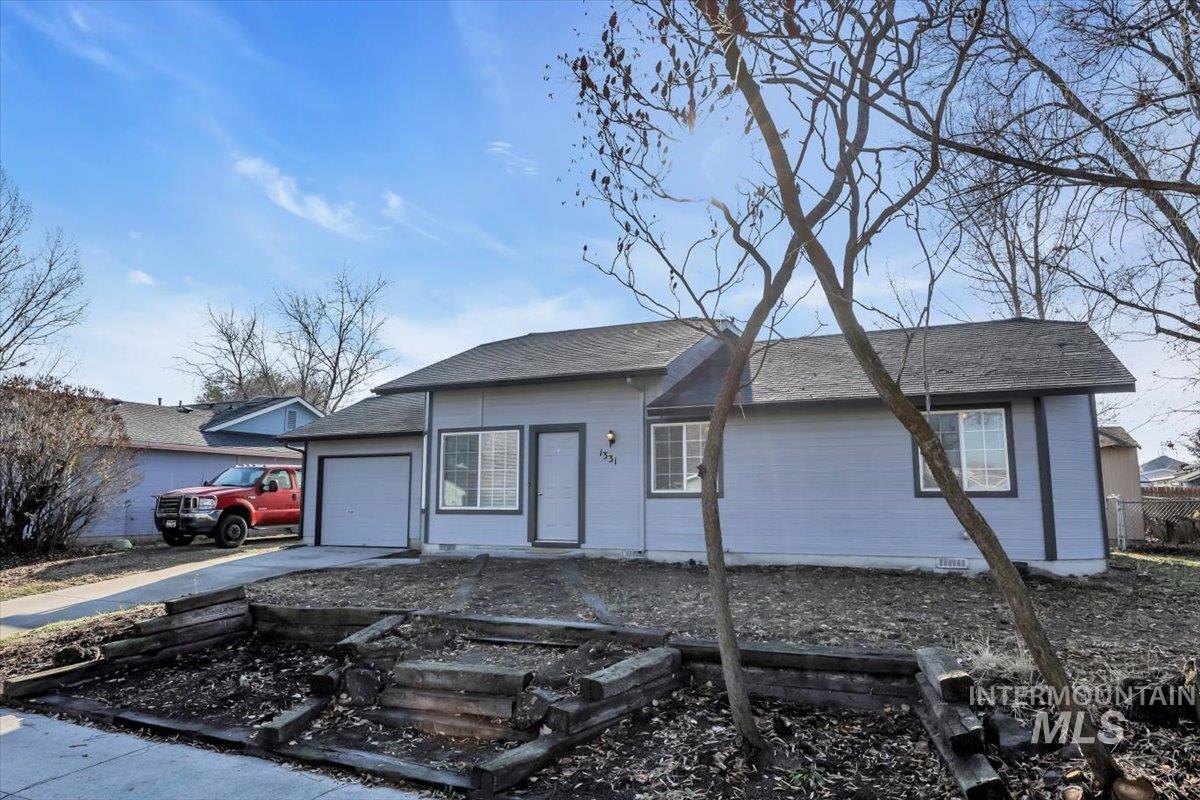 Ranch-style house featuring concrete driveway, an attached garage, and a shingled roof