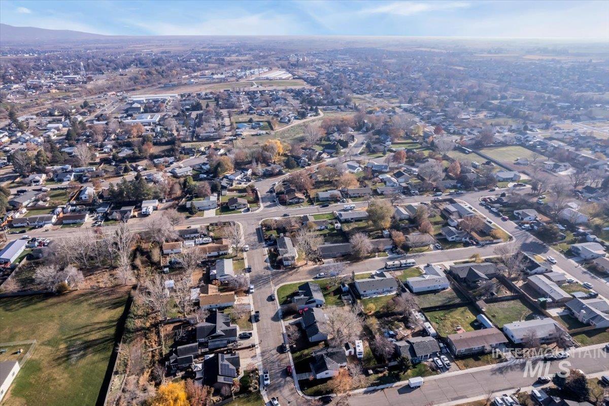 Aerial view of property and surrounding area with nearby suburban area