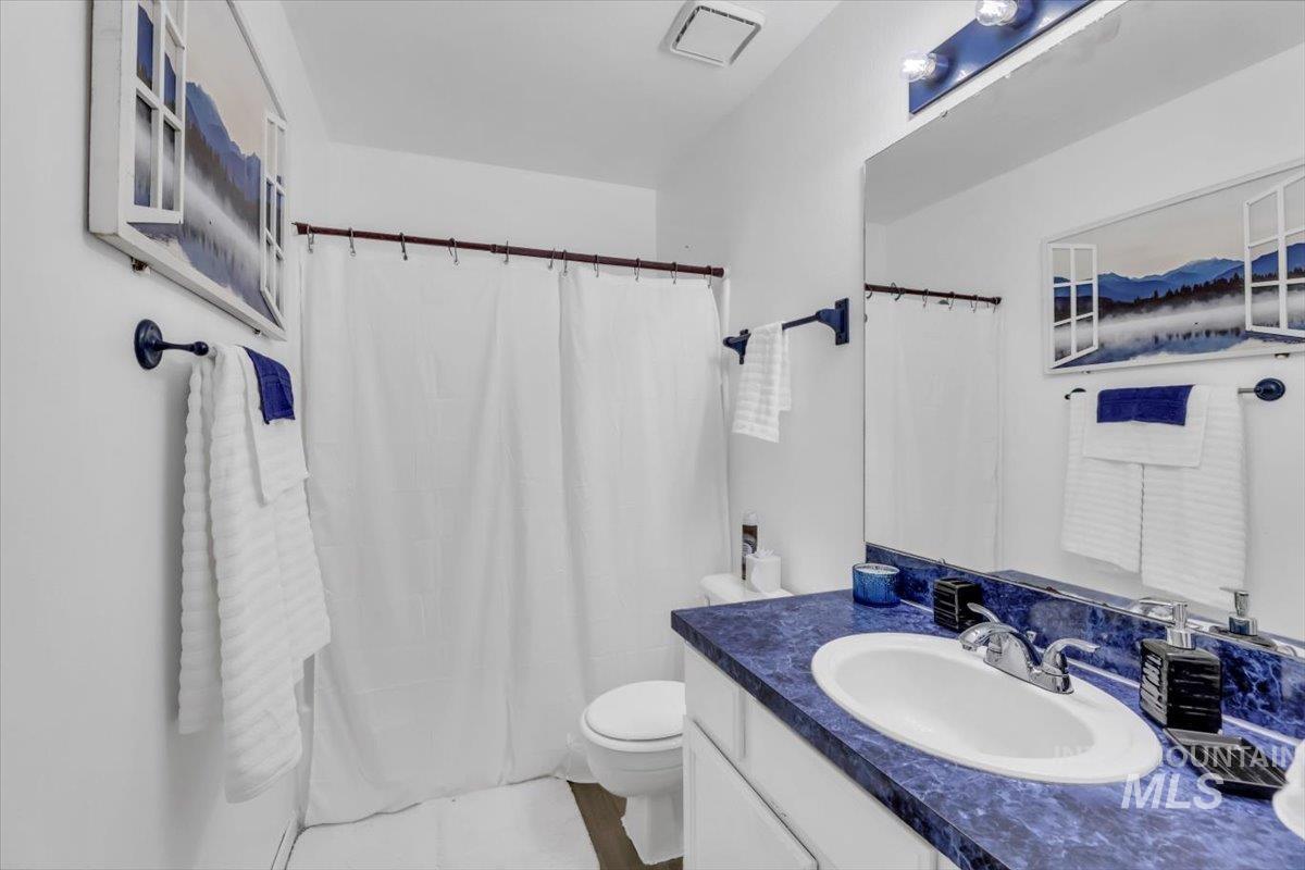 Bathroom with a shower with shower curtain, vanity, and tile patterned flooring