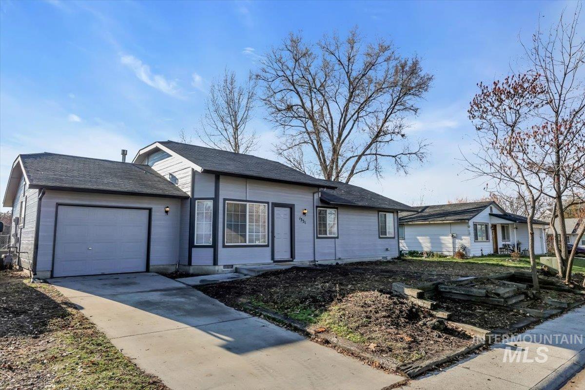 Ranch-style house with a garage, concrete driveway, and roof with shingles