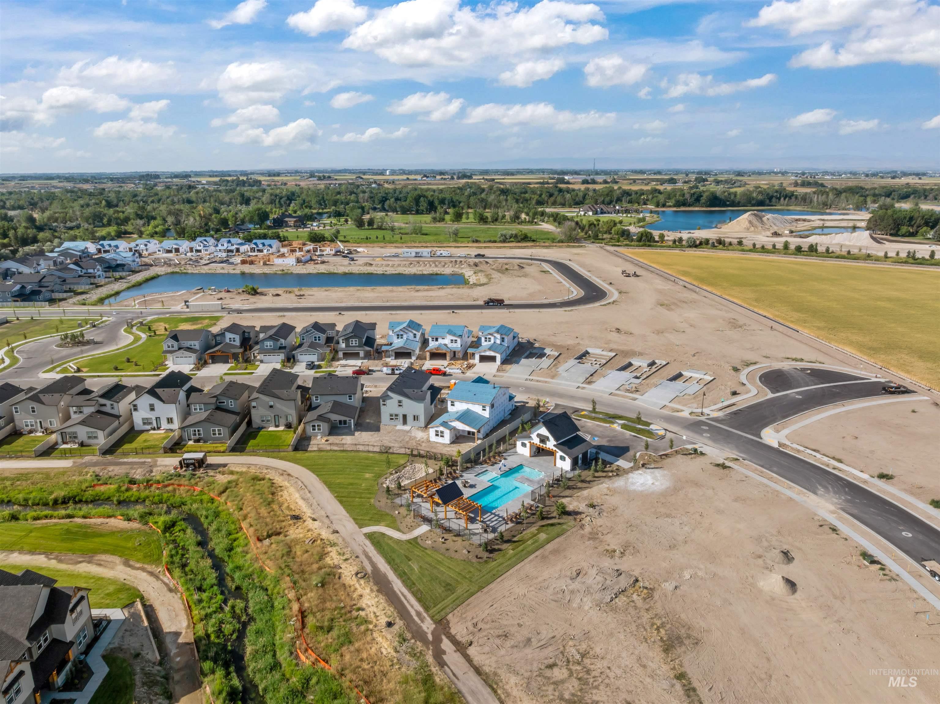 Aerial perspective of suburban area with a pool and a nearby body of water