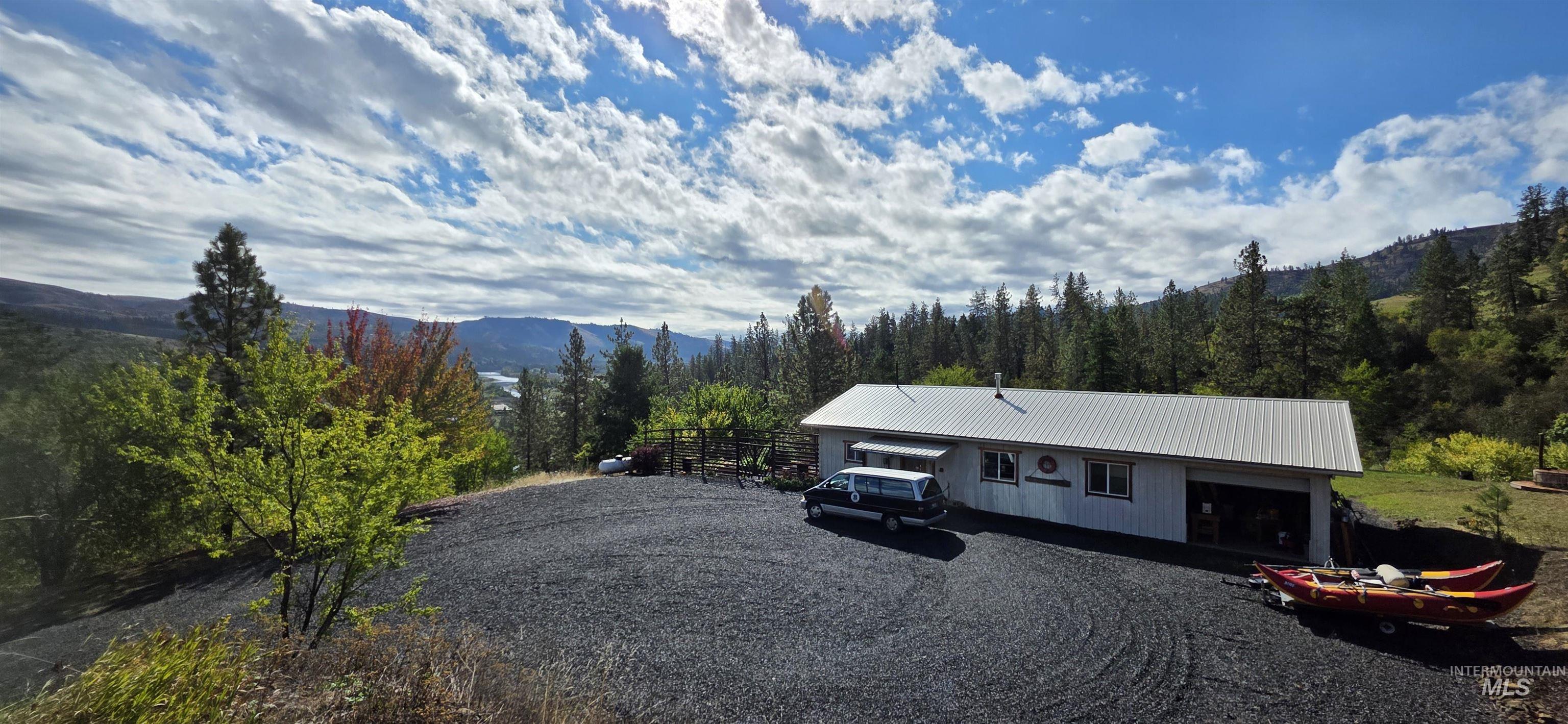 View of front of home with a metal roof, a view of trees, and a mountain view