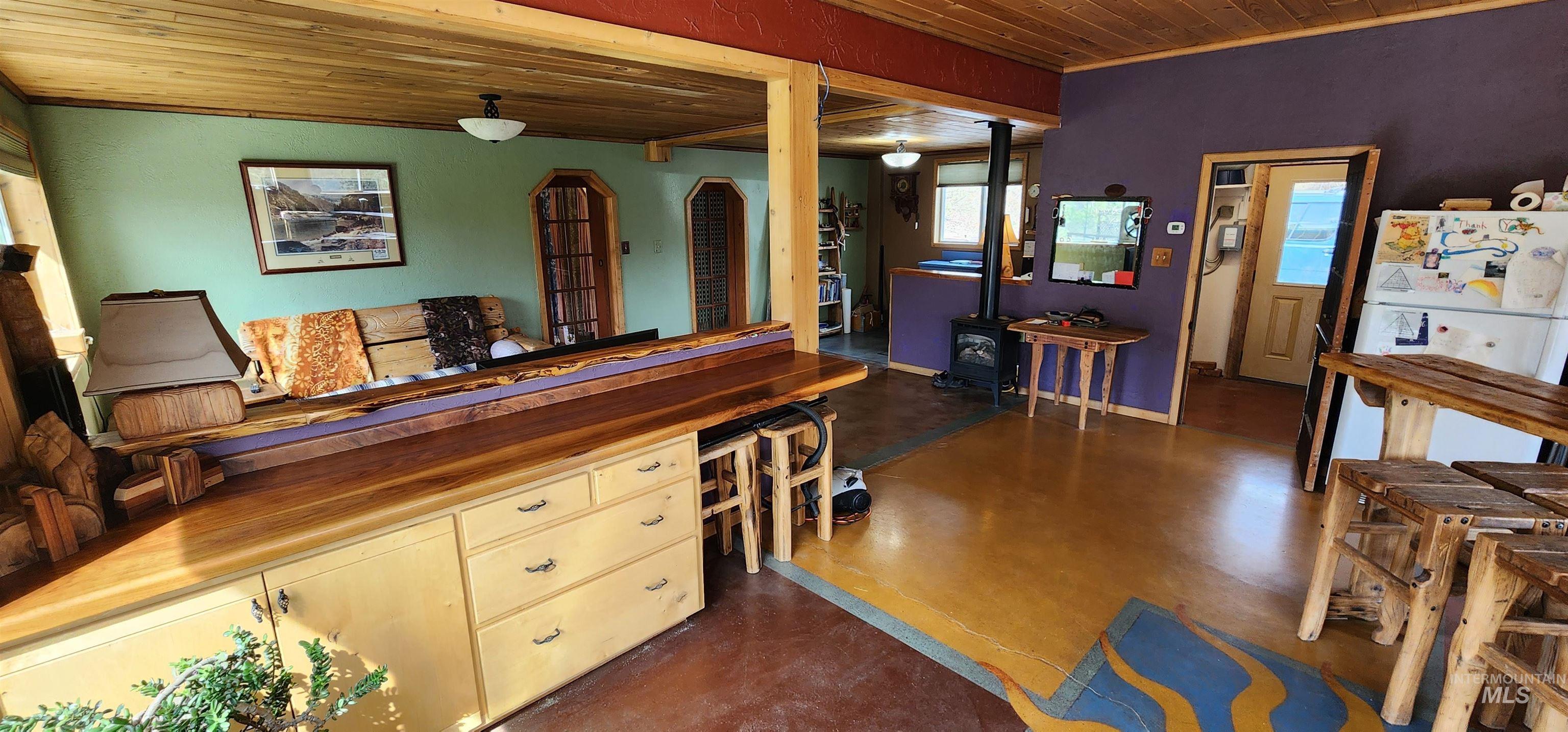 Kitchen featuring concrete flooring, cream cabinetry, wood ceiling, and wood counters