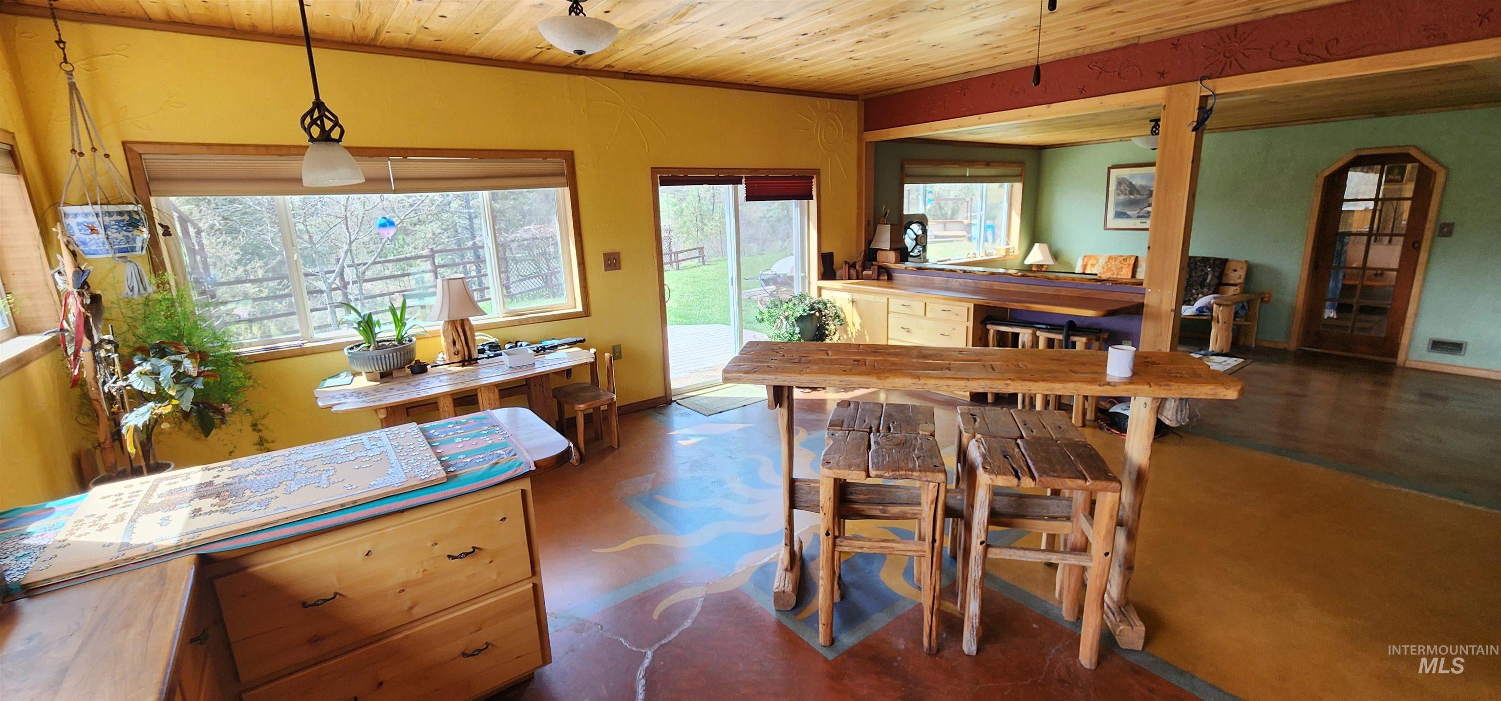 Dining space with wooden ceiling, concrete flooring, and arched walkways
