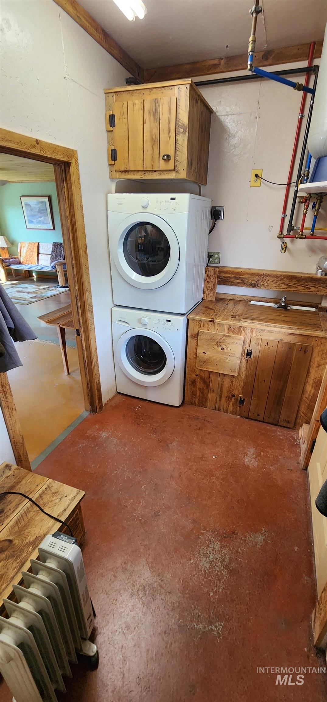 Laundry room featuring radiator and cabinet space