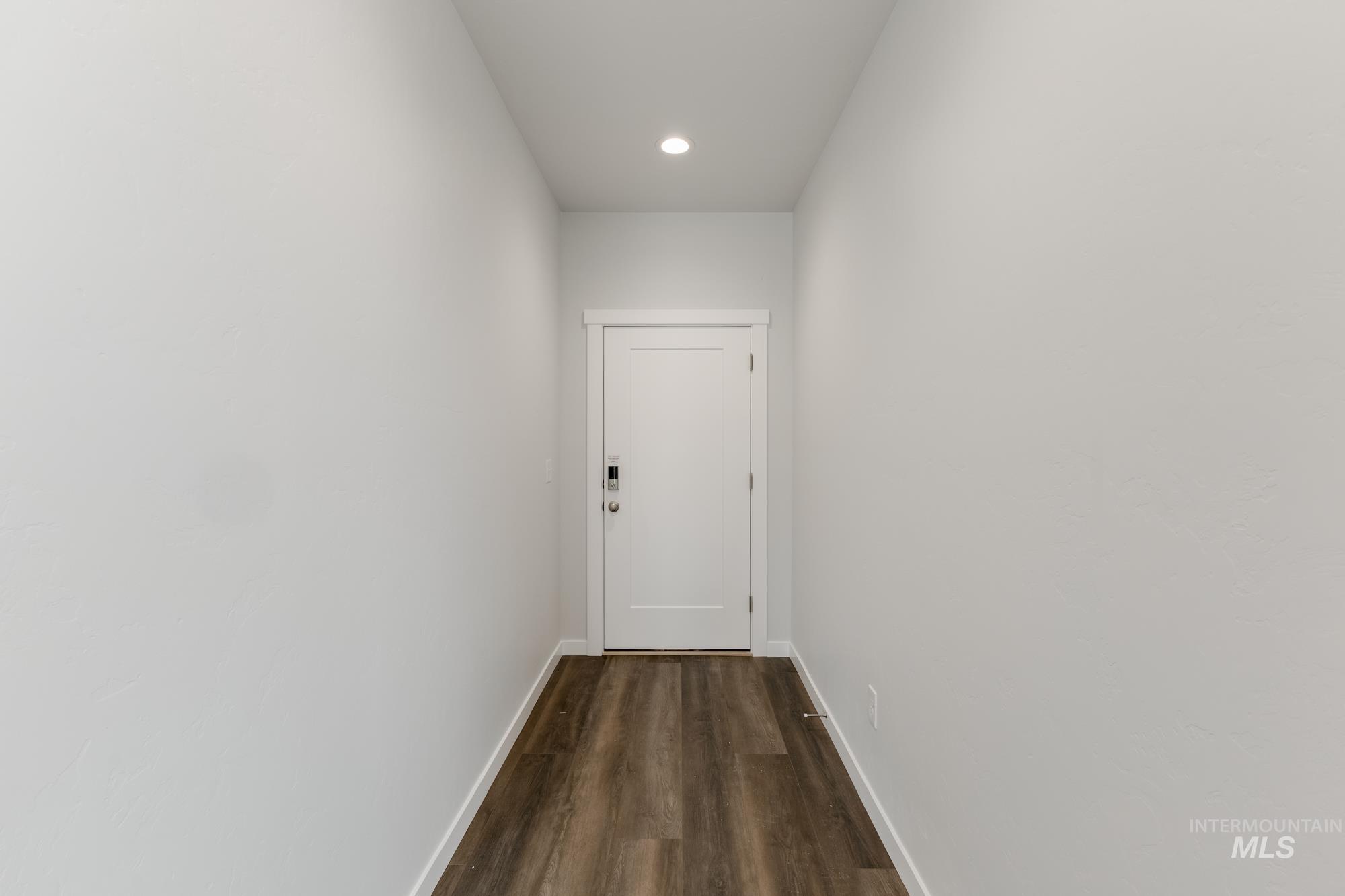 Corridor with dark wood finished floors and recessed lighting