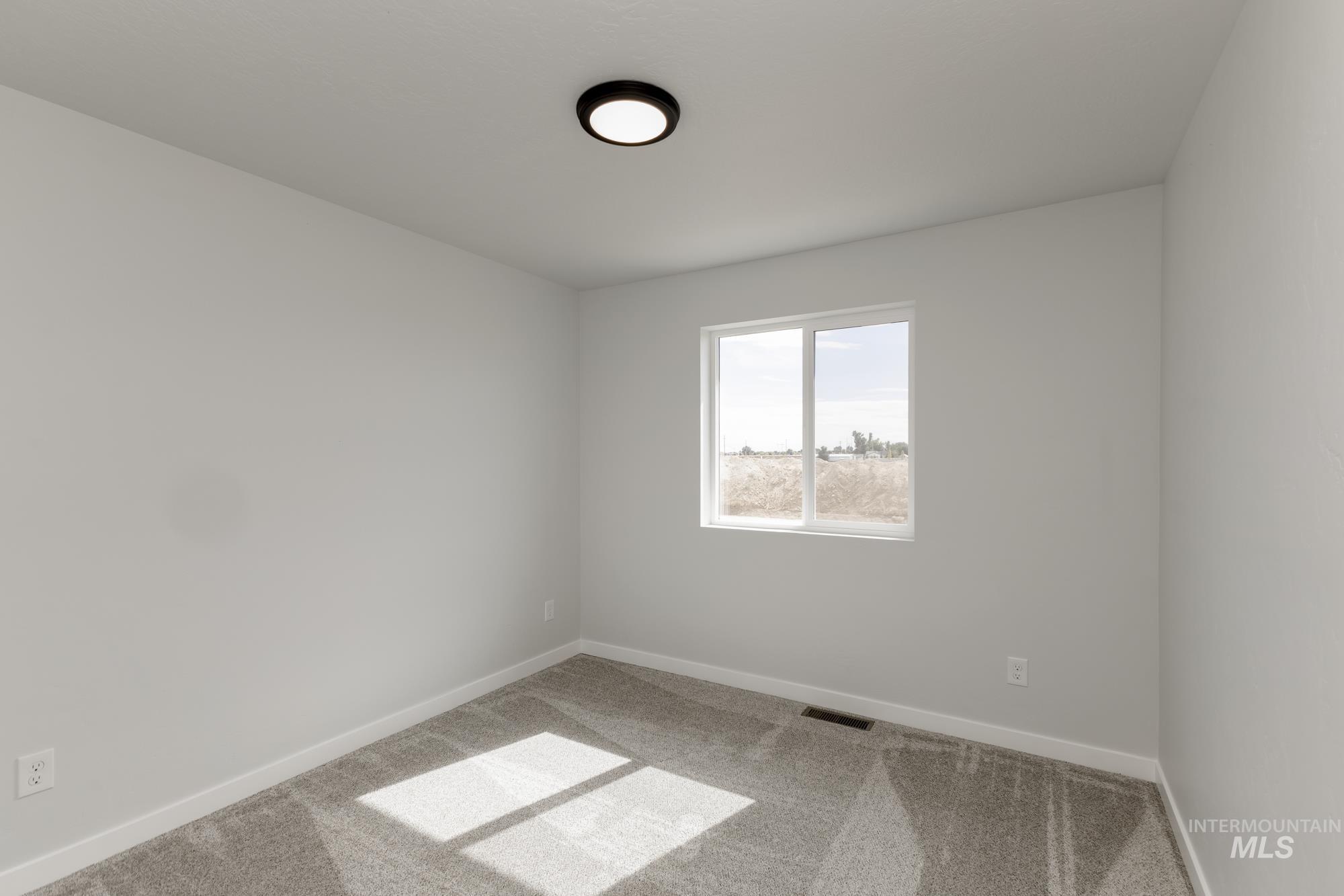 Carpeted empty room featuring baseboards