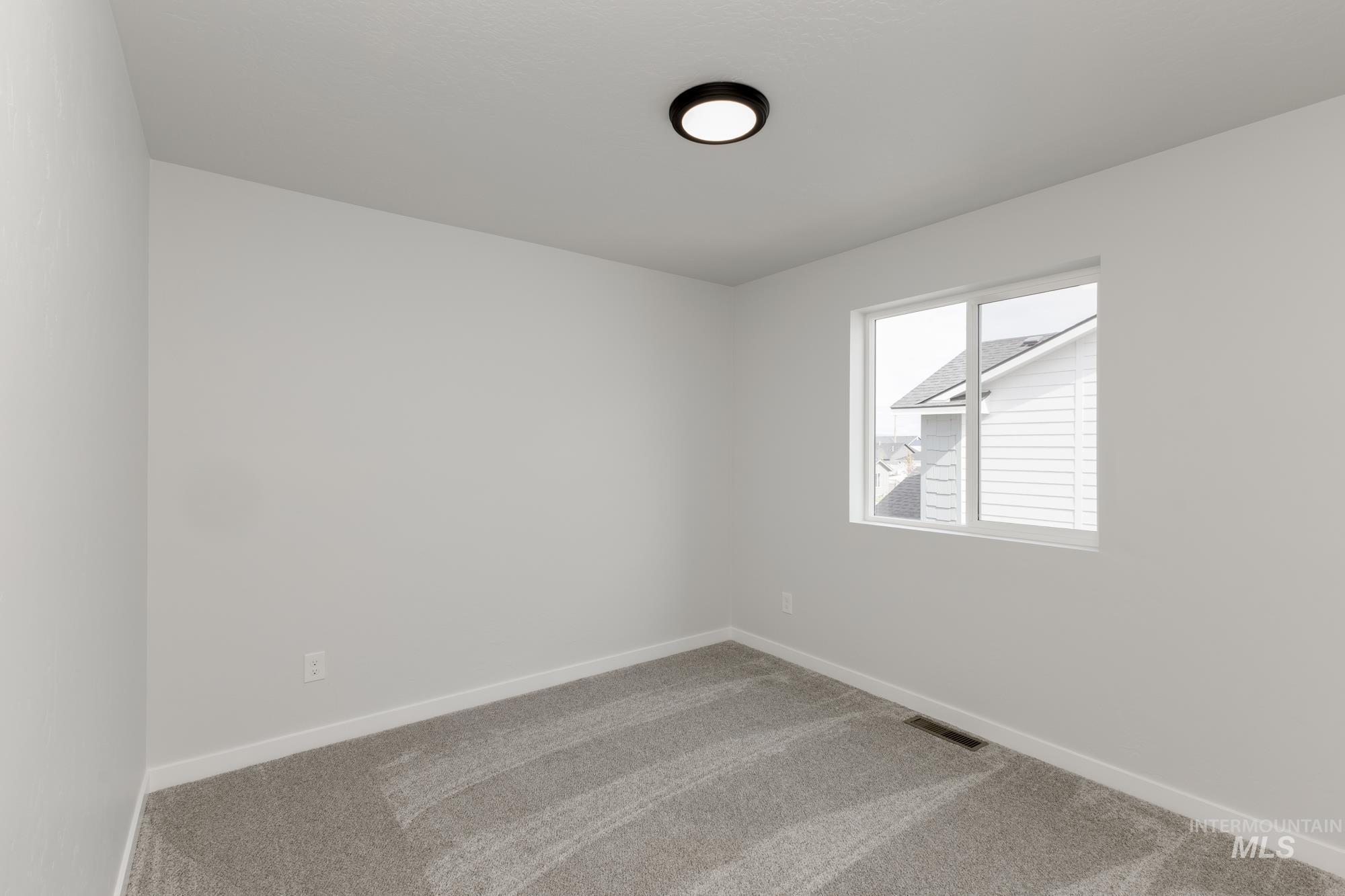 Carpeted spare room with baseboards