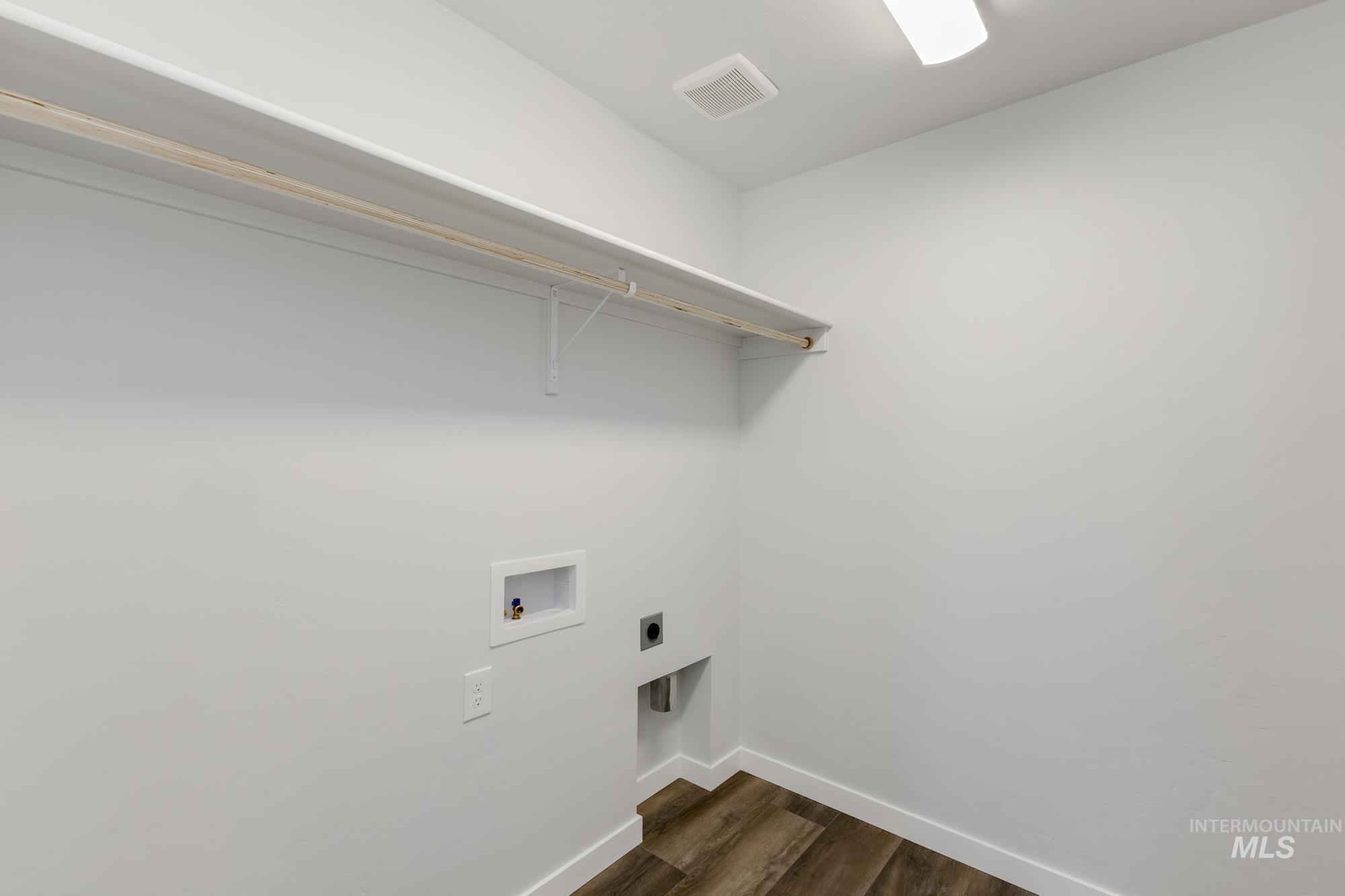 Washroom featuring dark wood finished floors, hookup for a washing machine, and electric dryer hookup