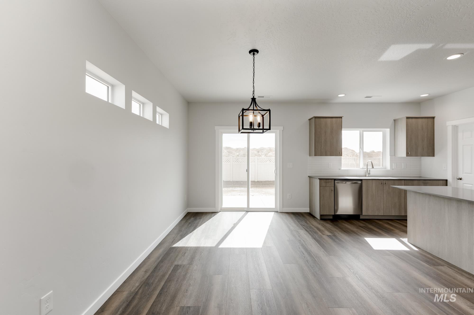 Unfurnished dining area featuring a chandelier, dark wood-style floors, and recessed lighting