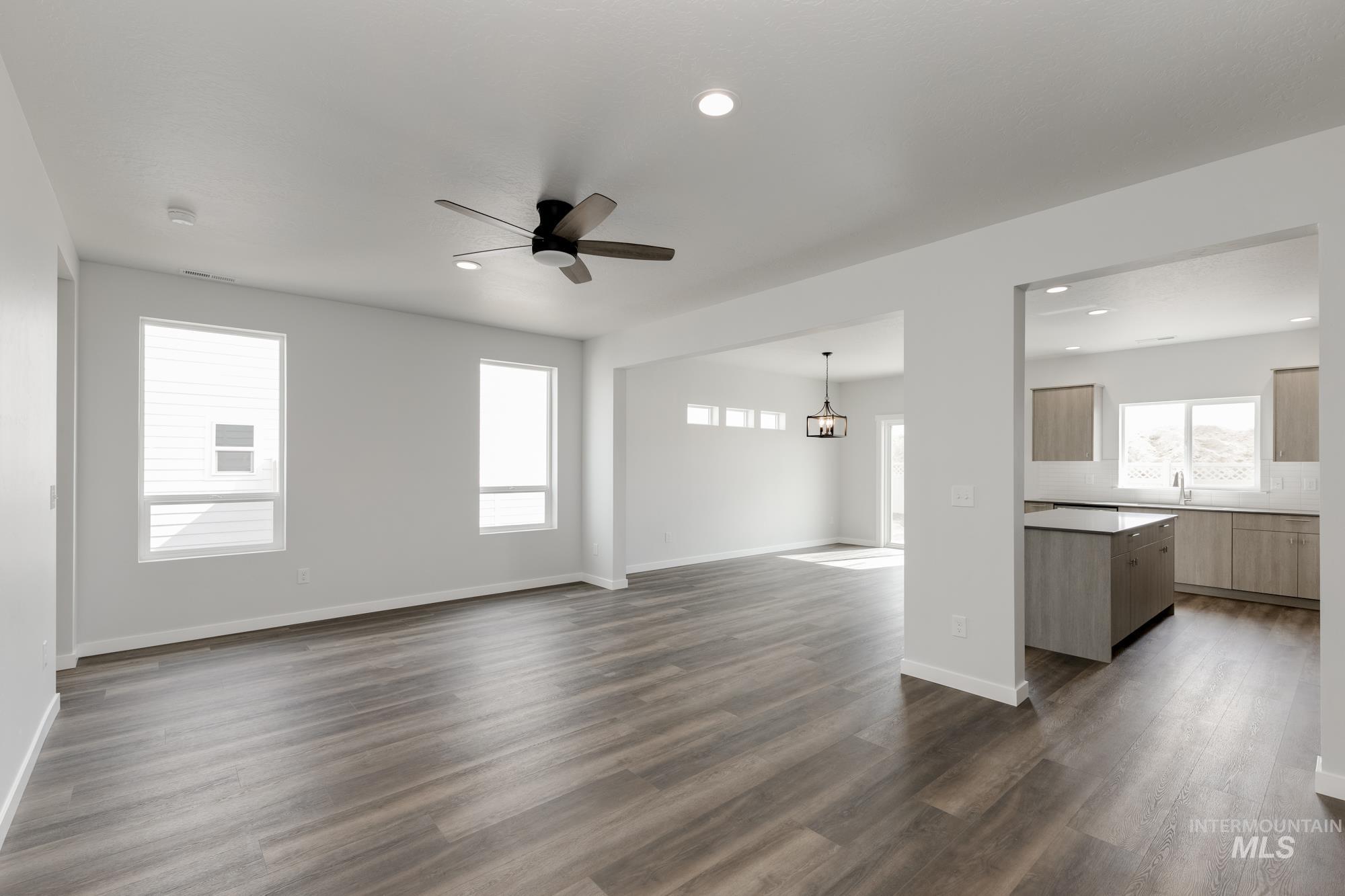 Unfurnished living room with ceiling fan, dark wood-style floors, and recessed lighting