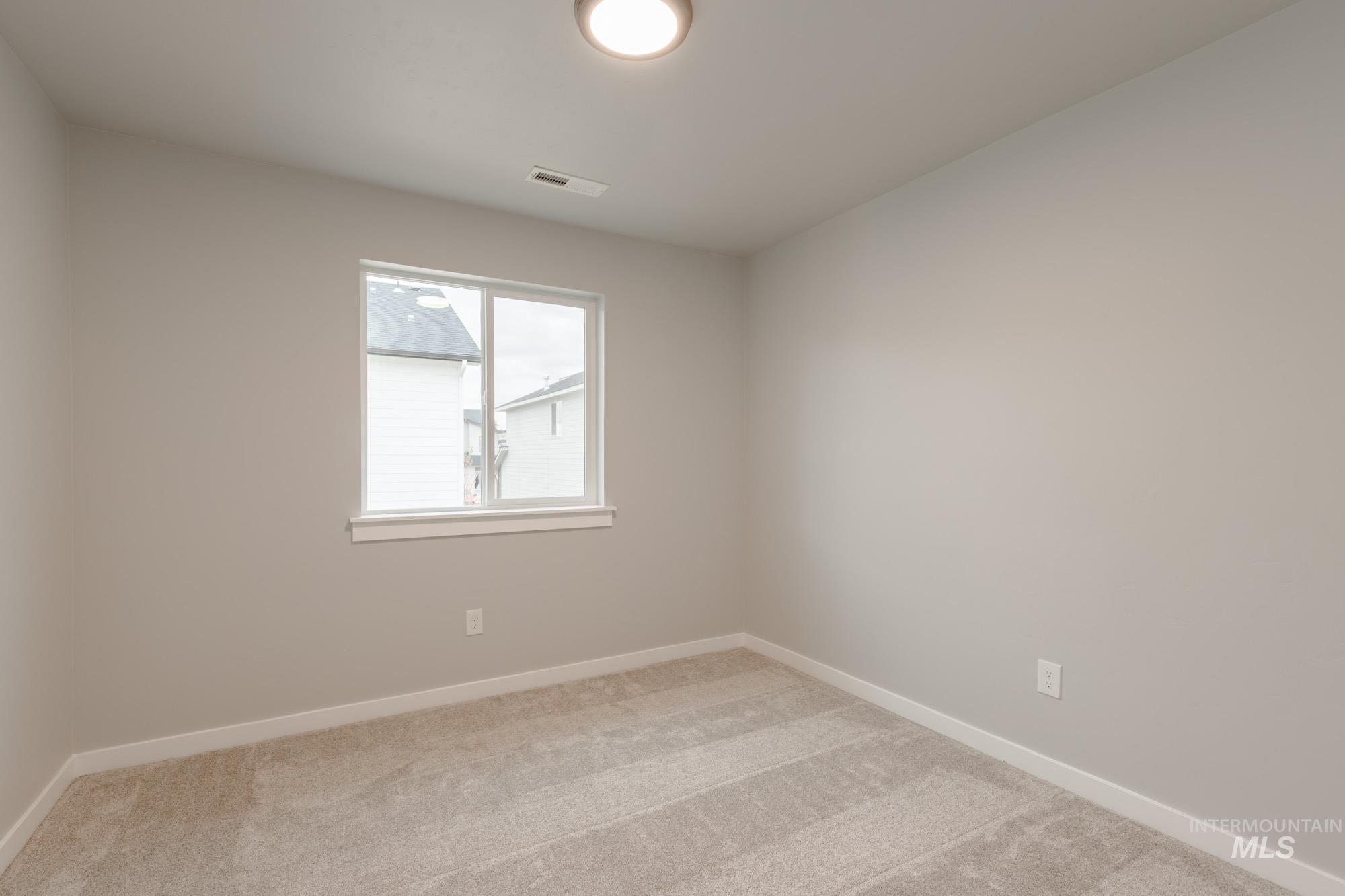 Spare room with baseboards and light carpet
