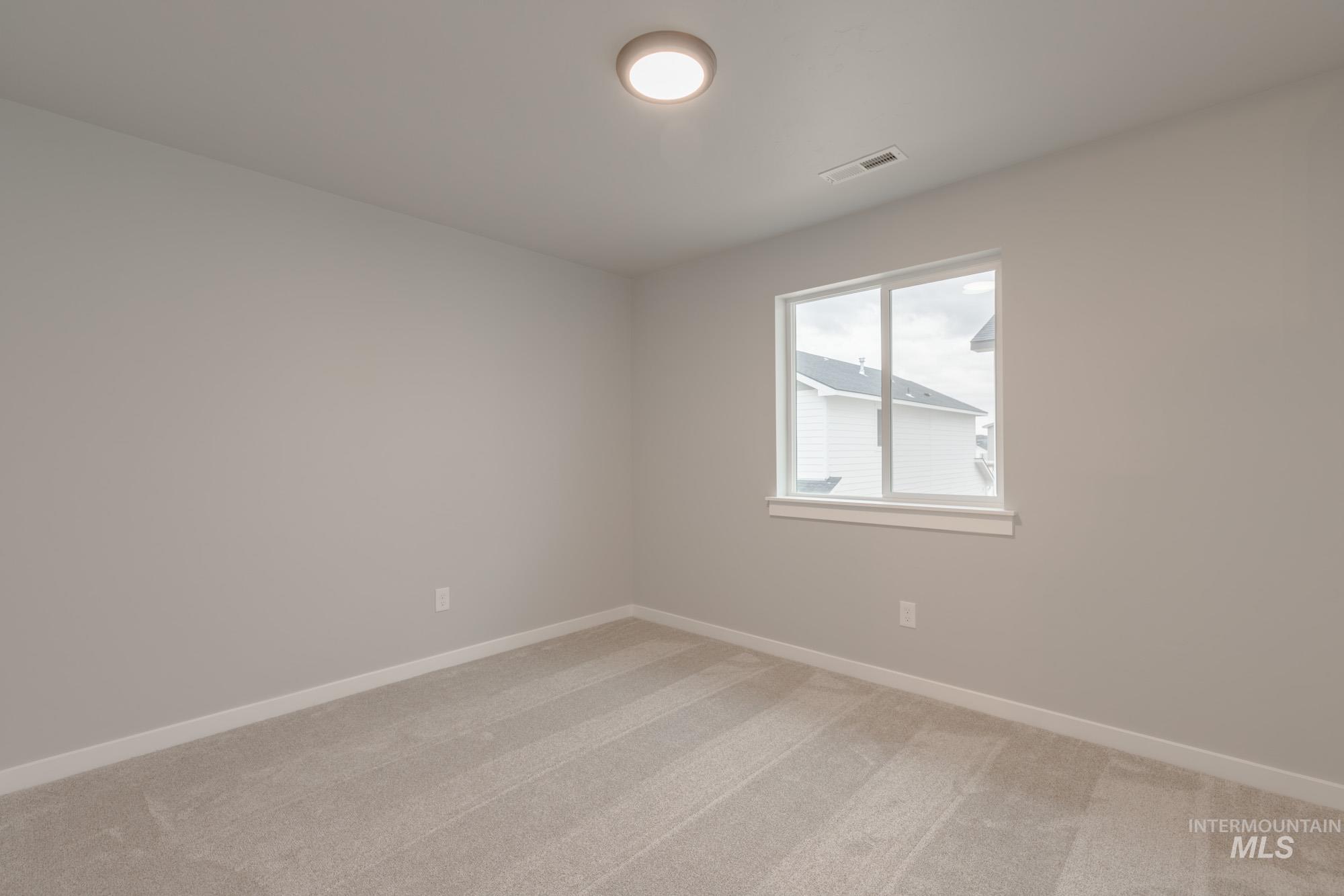 Unfurnished room with light carpet and baseboards
