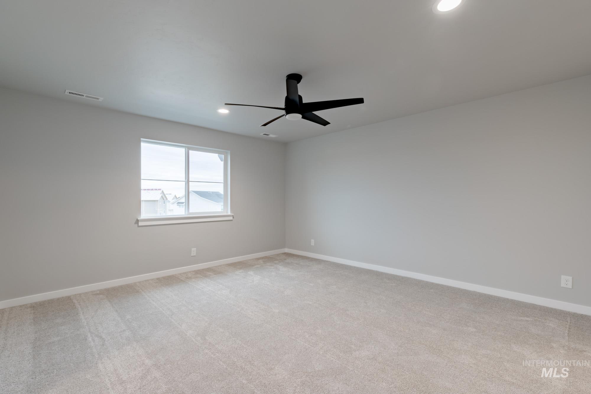 Spare room featuring light colored carpet, recessed lighting, and a ceiling fan