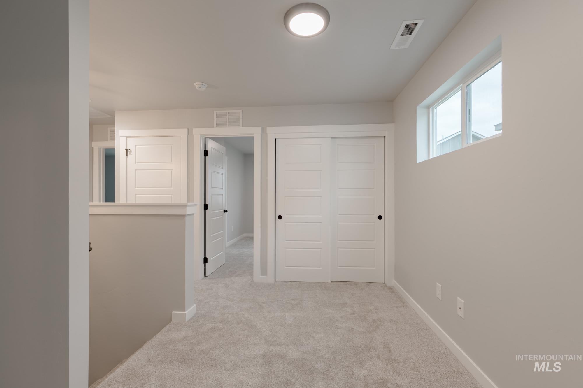 Basement featuring light carpet and baseboards