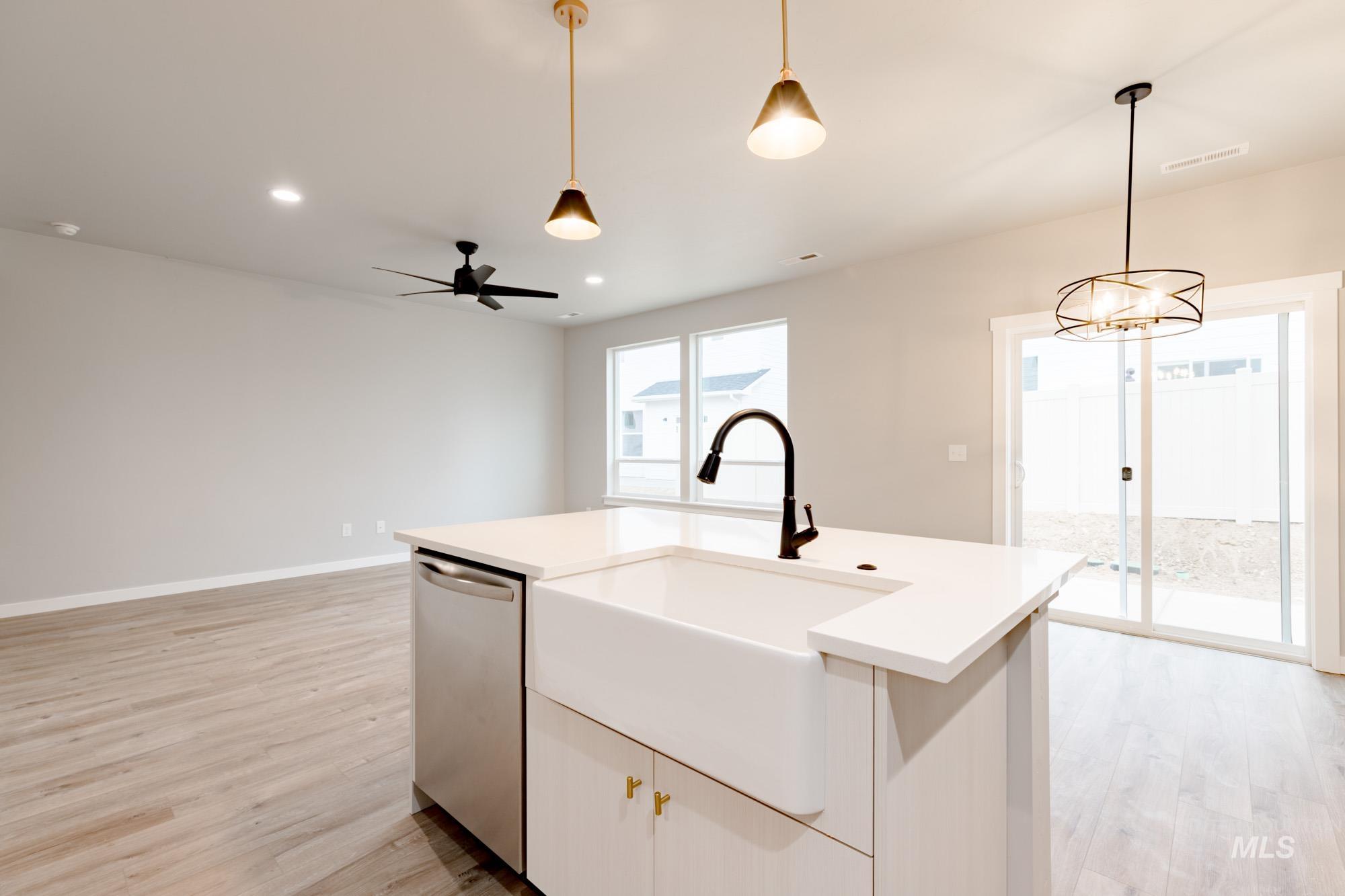 Kitchen featuring pendant lighting, light wood-type flooring, dishwasher, recessed lighting, and a kitchen island with sink