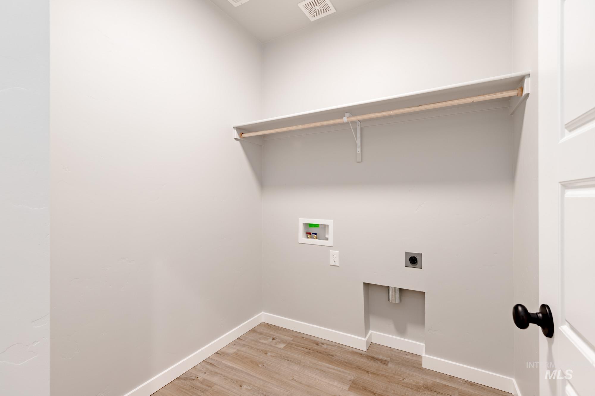 Washroom featuring electric dryer hookup, light wood finished floors, and washer hookup