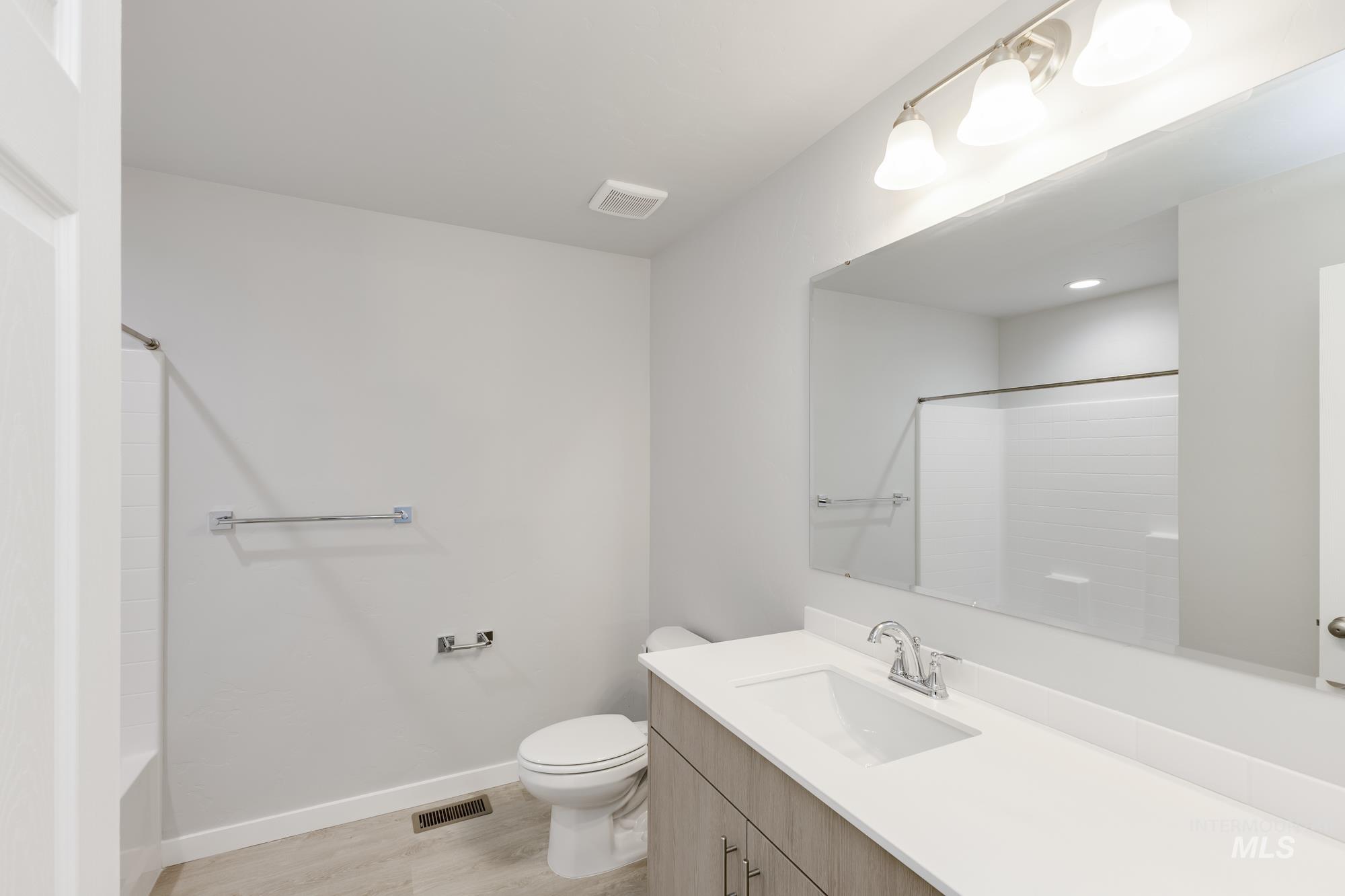 Full bath with vanity and light wood-type flooring