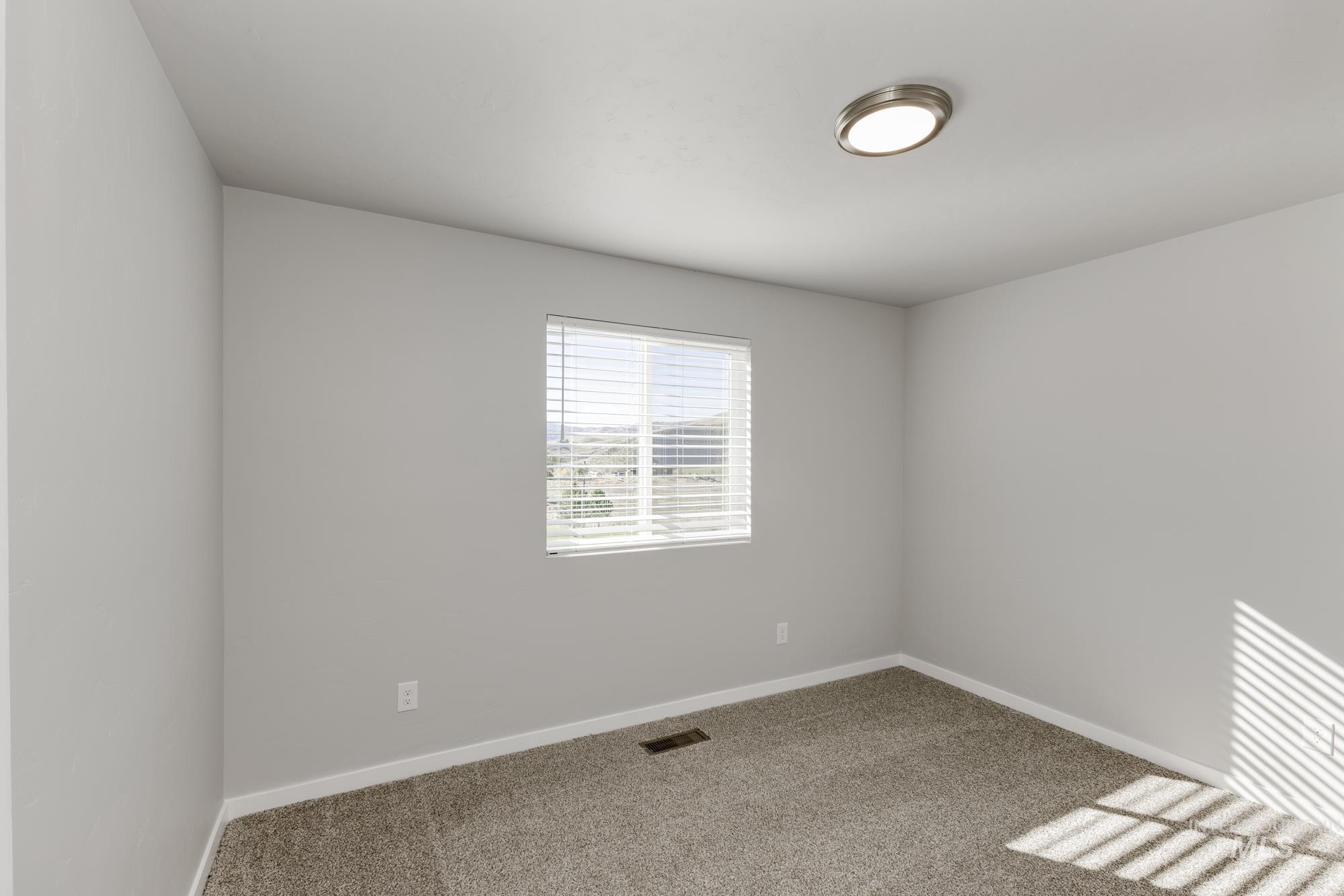 Carpeted empty room with baseboards