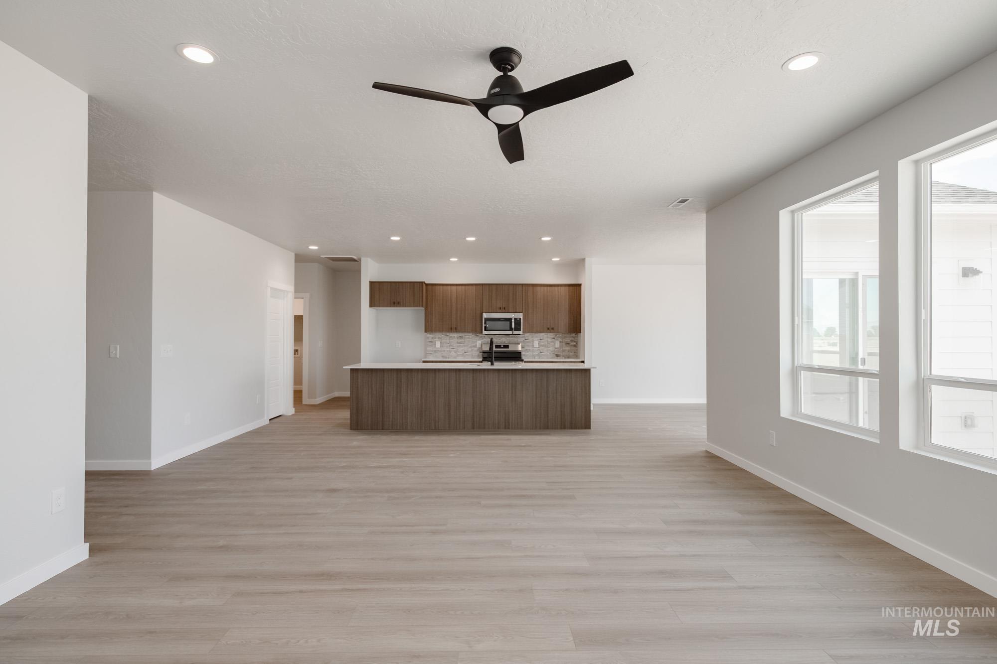 Kitchen featuring open floor plan, light countertops, light wood finished floors, and recessed lighting