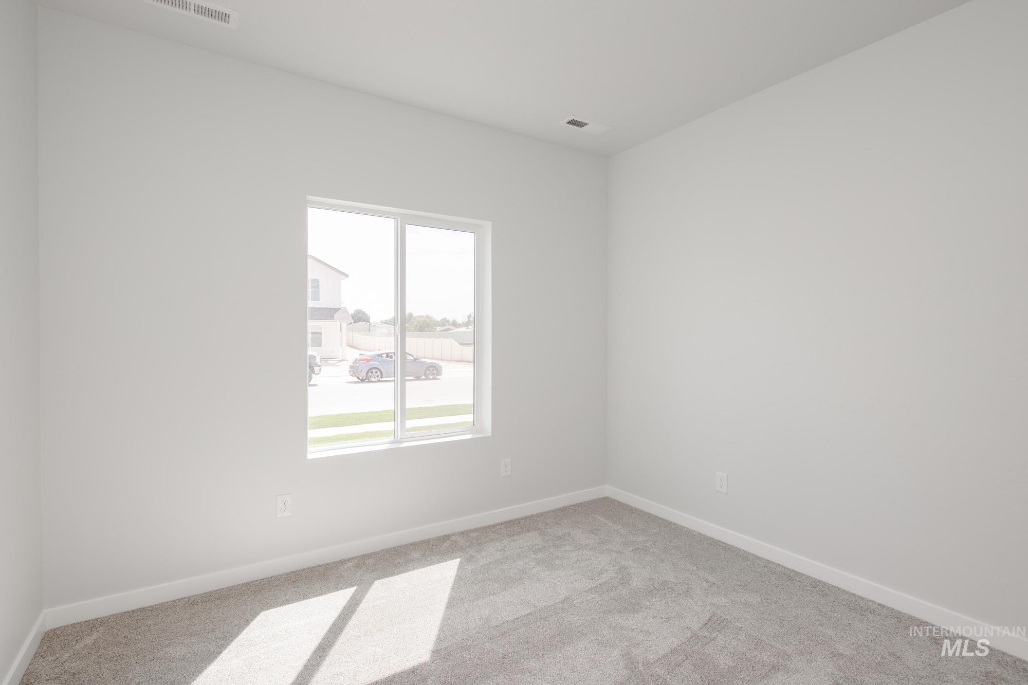 Spare room featuring carpet floors and baseboards