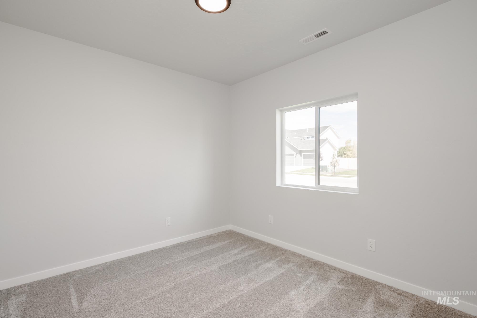 Empty room with carpet and baseboards