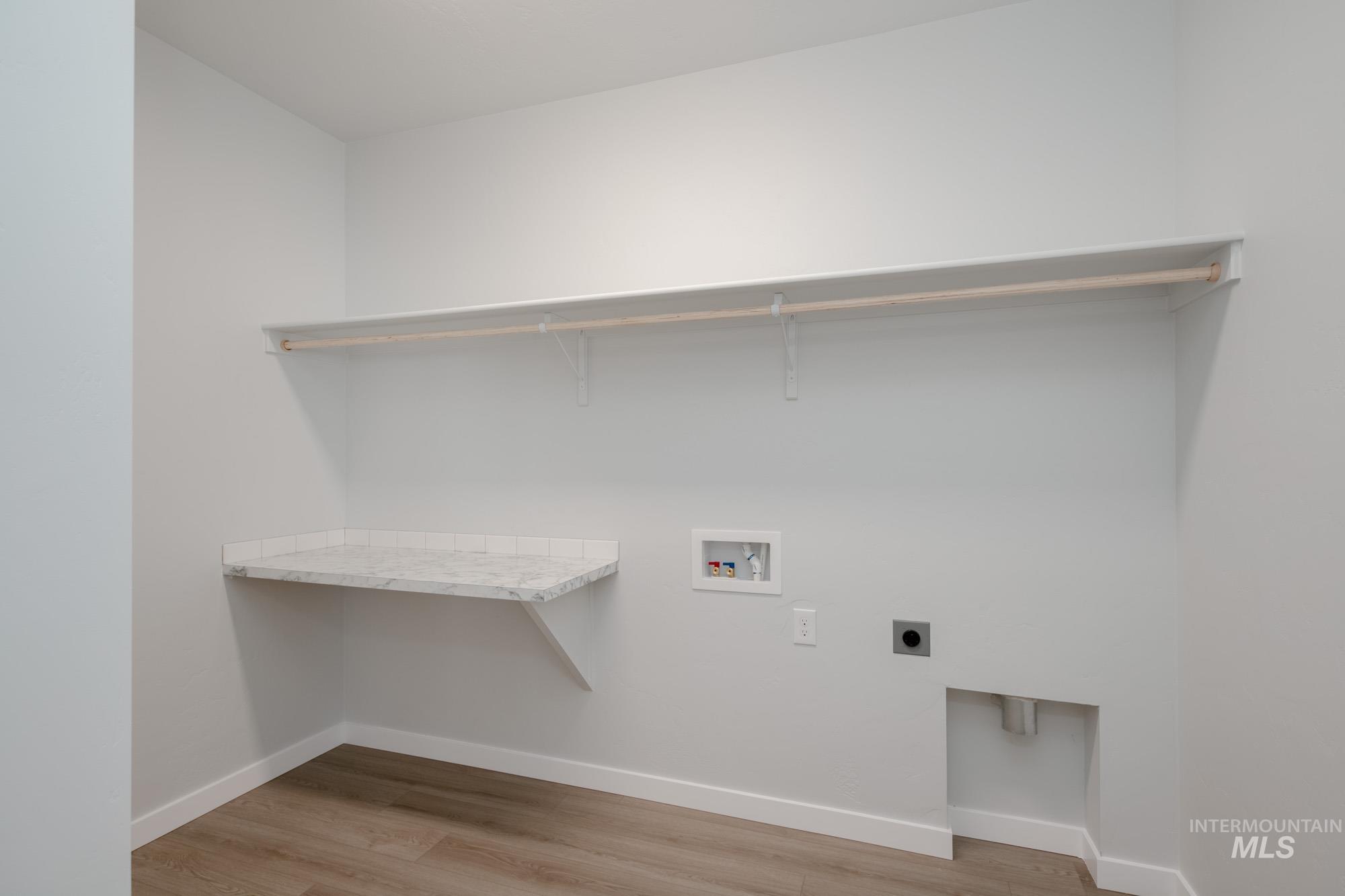 Laundry room with light wood-style flooring, washer hookup, and electric dryer hookup