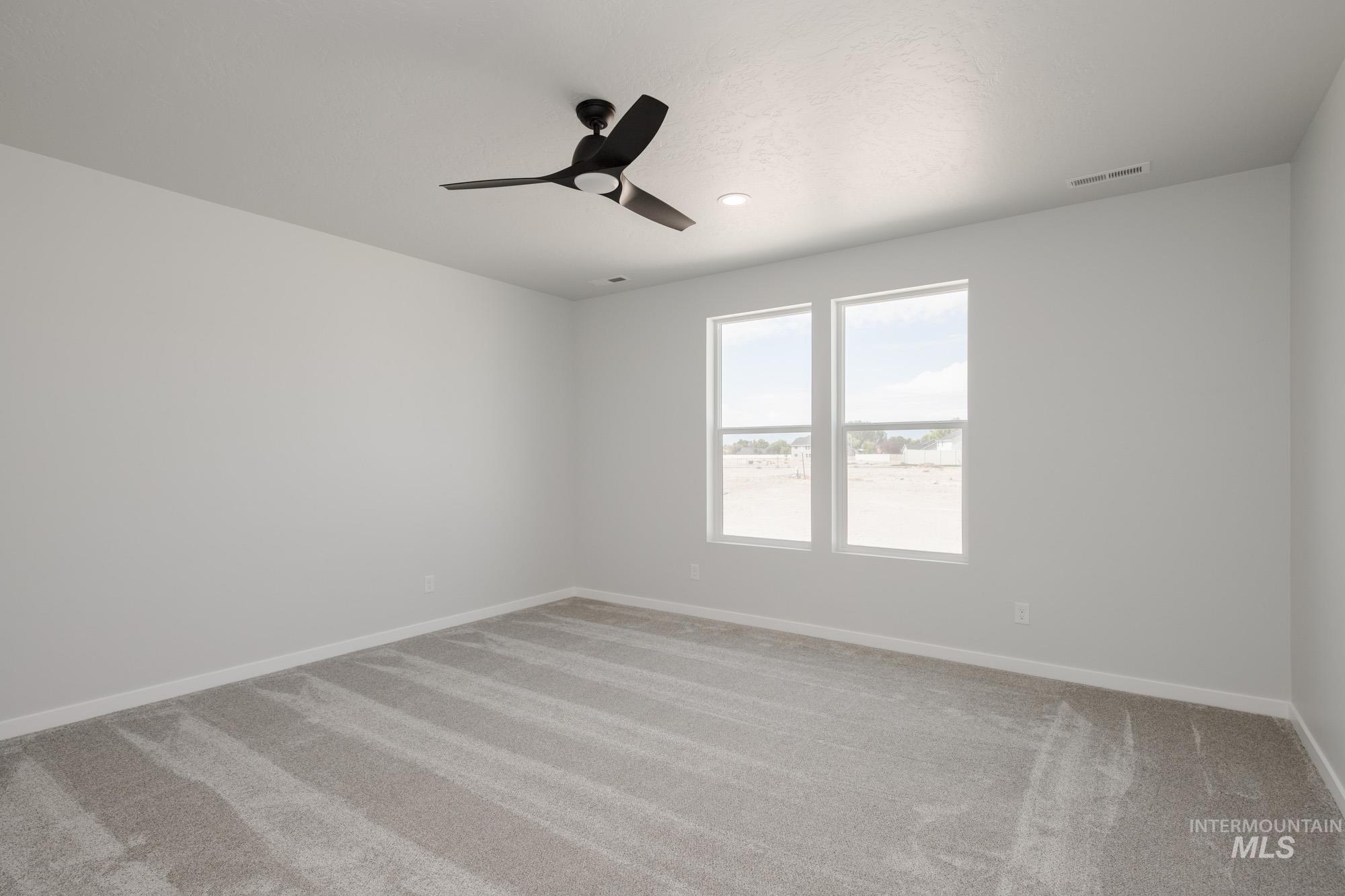 Empty room with light colored carpet, ceiling fan, and recessed lighting