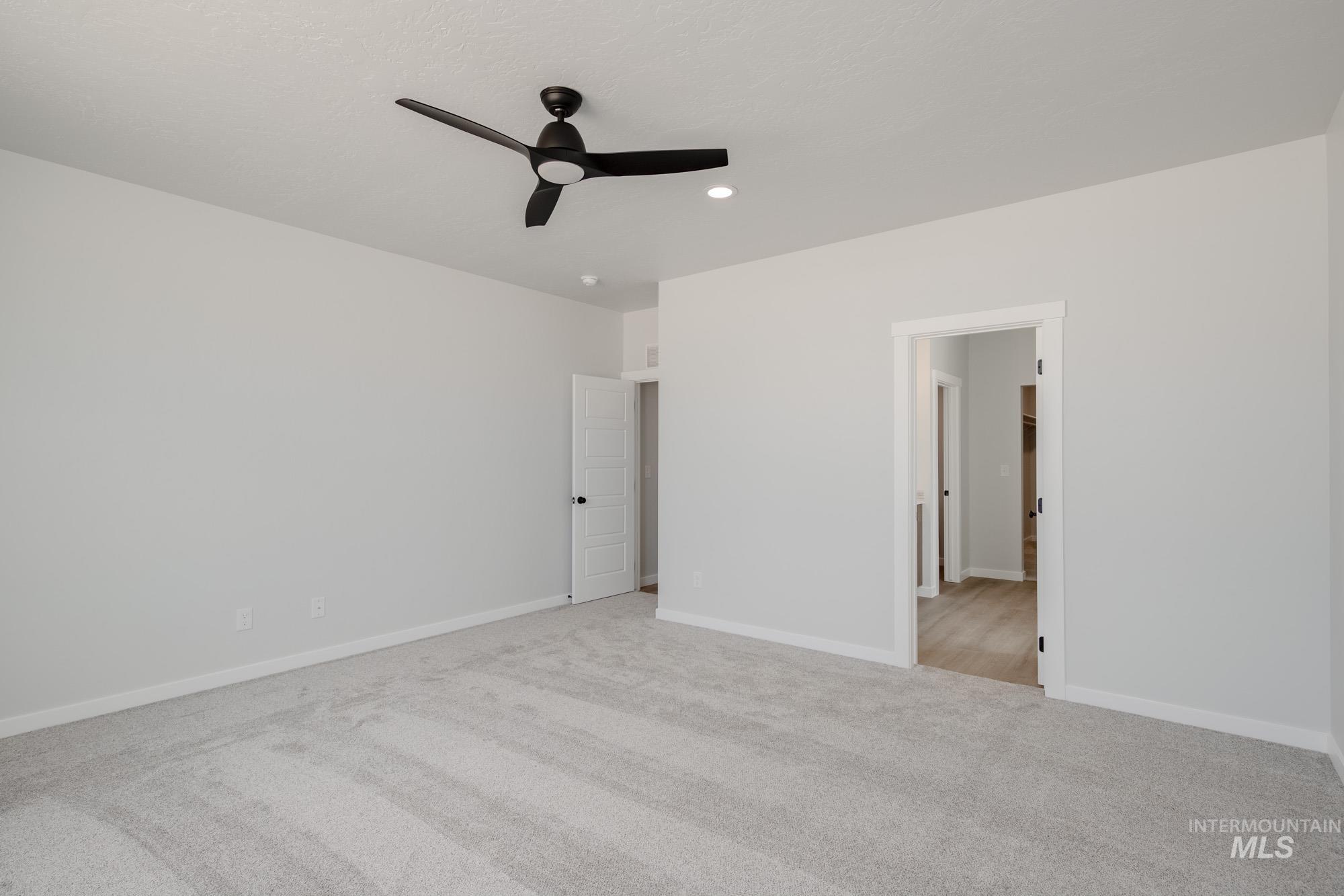 Unfurnished bedroom featuring light colored carpet, ceiling fan, and recessed lighting