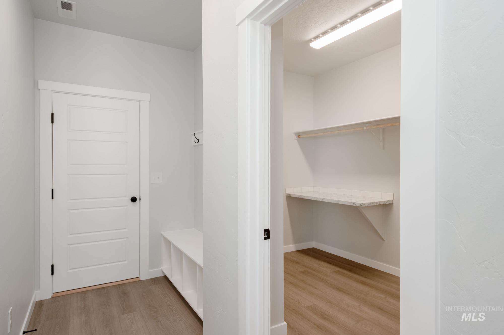 Mudroom featuring light wood-type flooring and baseboards
