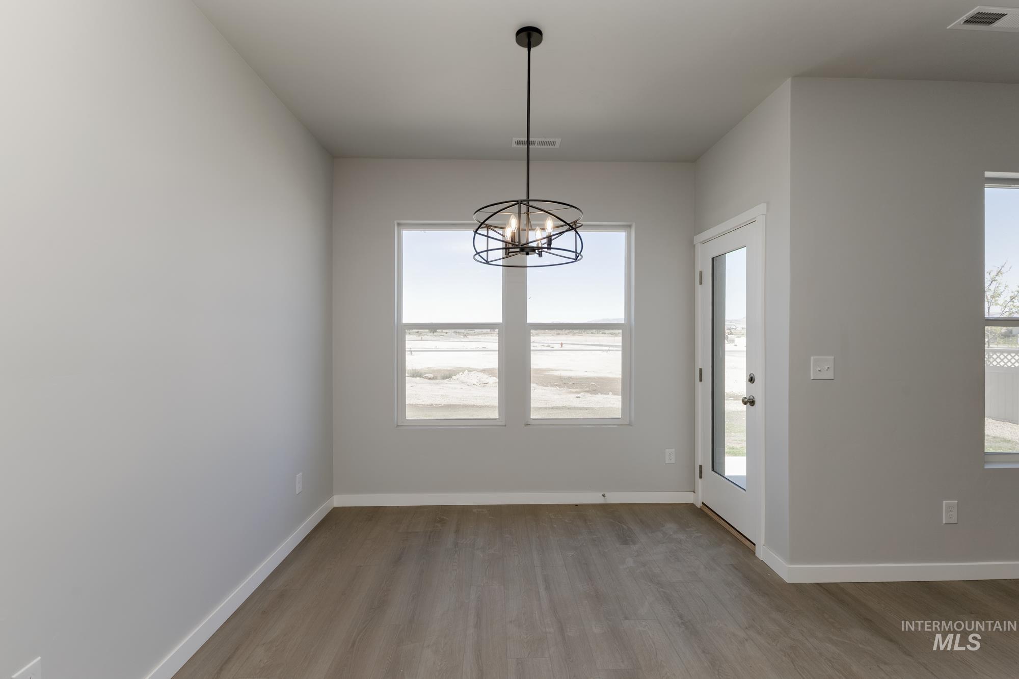 Unfurnished dining area featuring light wood-style floors and a chandelier