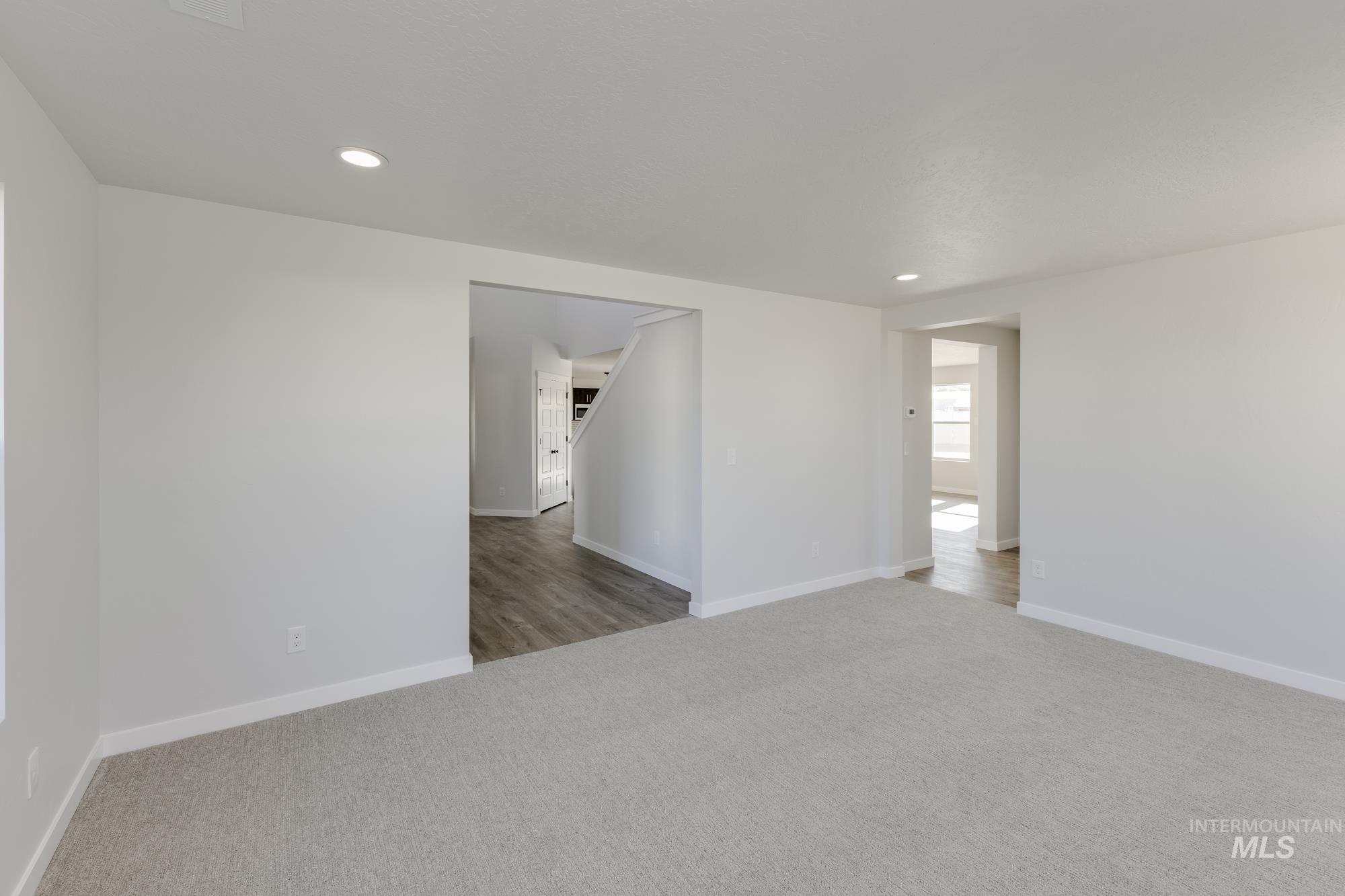 Spare room featuring light colored carpet and recessed lighting