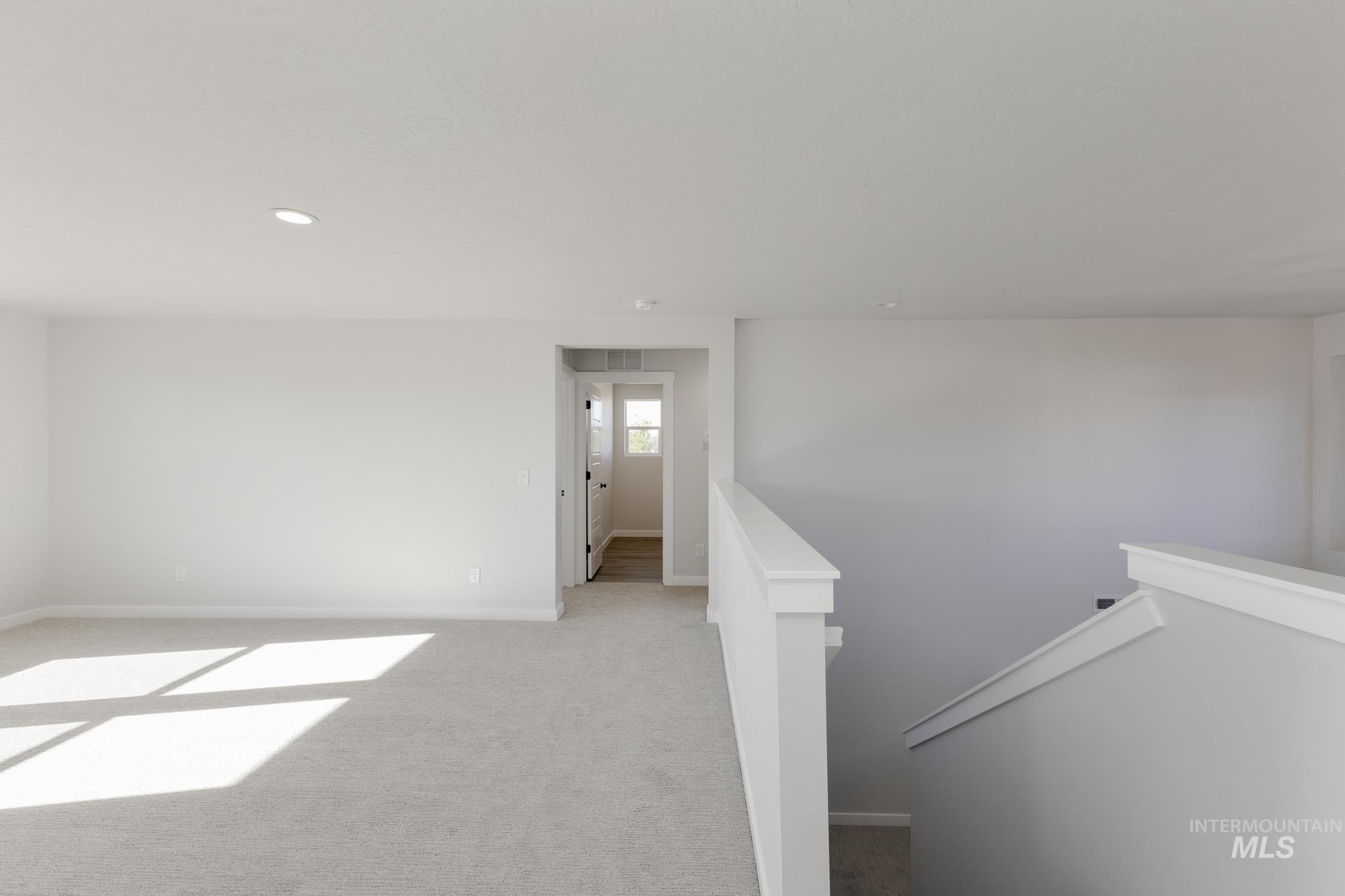 Carpeted spare room featuring baseboards and recessed lighting