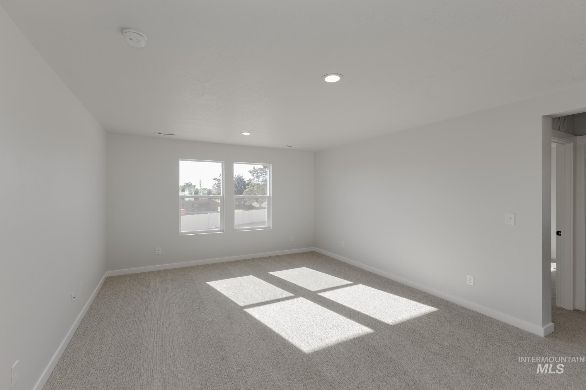 Unfurnished room with light colored carpet and recessed lighting