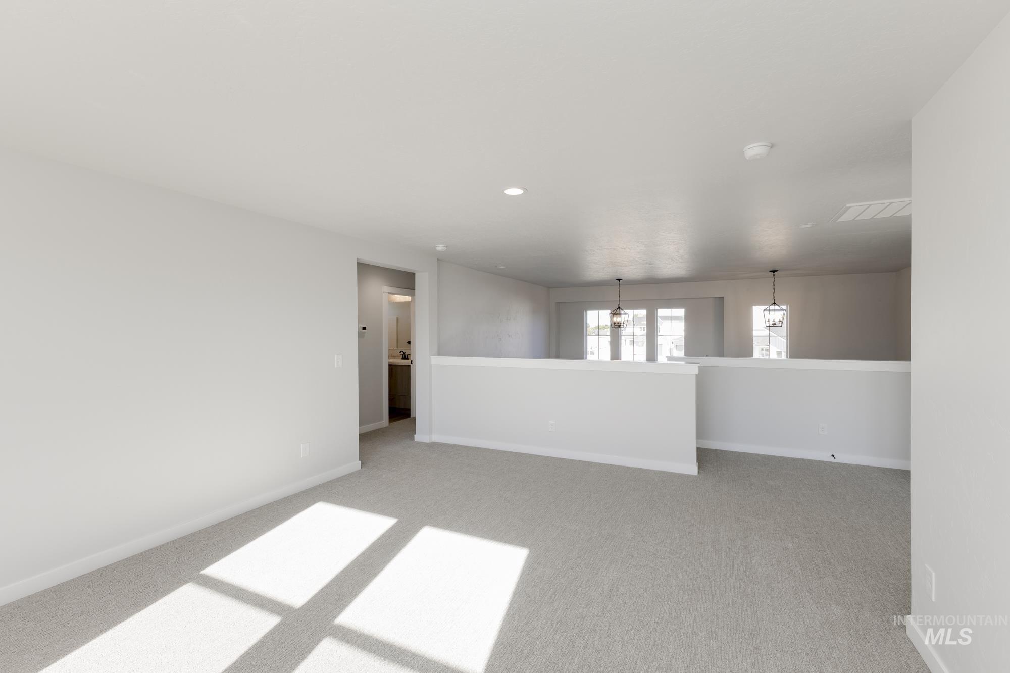 Unfurnished room with light colored carpet, a chandelier, and recessed lighting