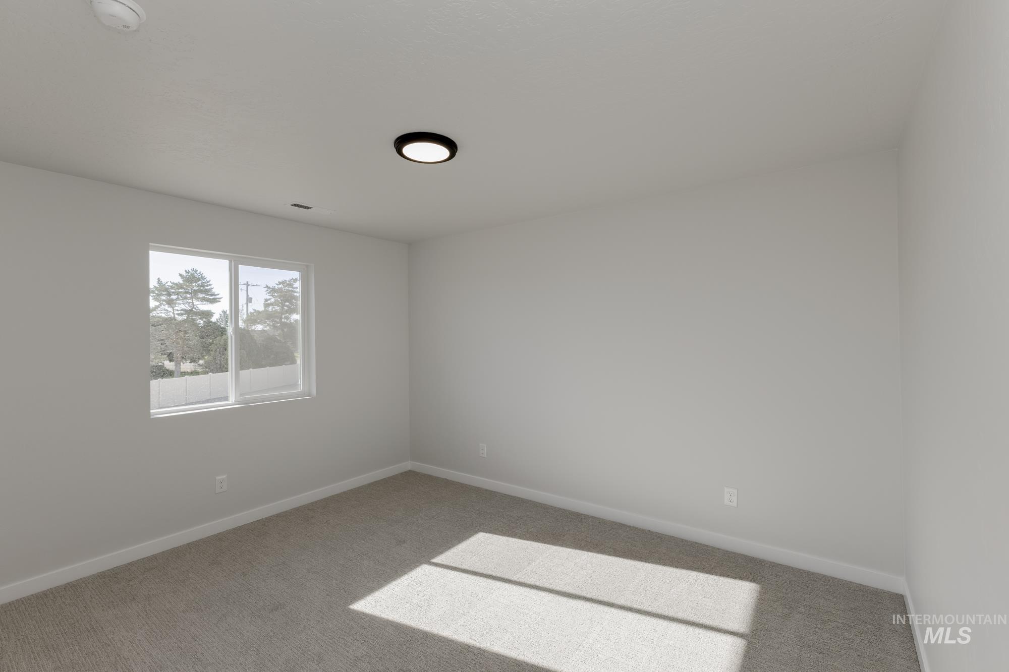 Carpeted empty room with baseboards