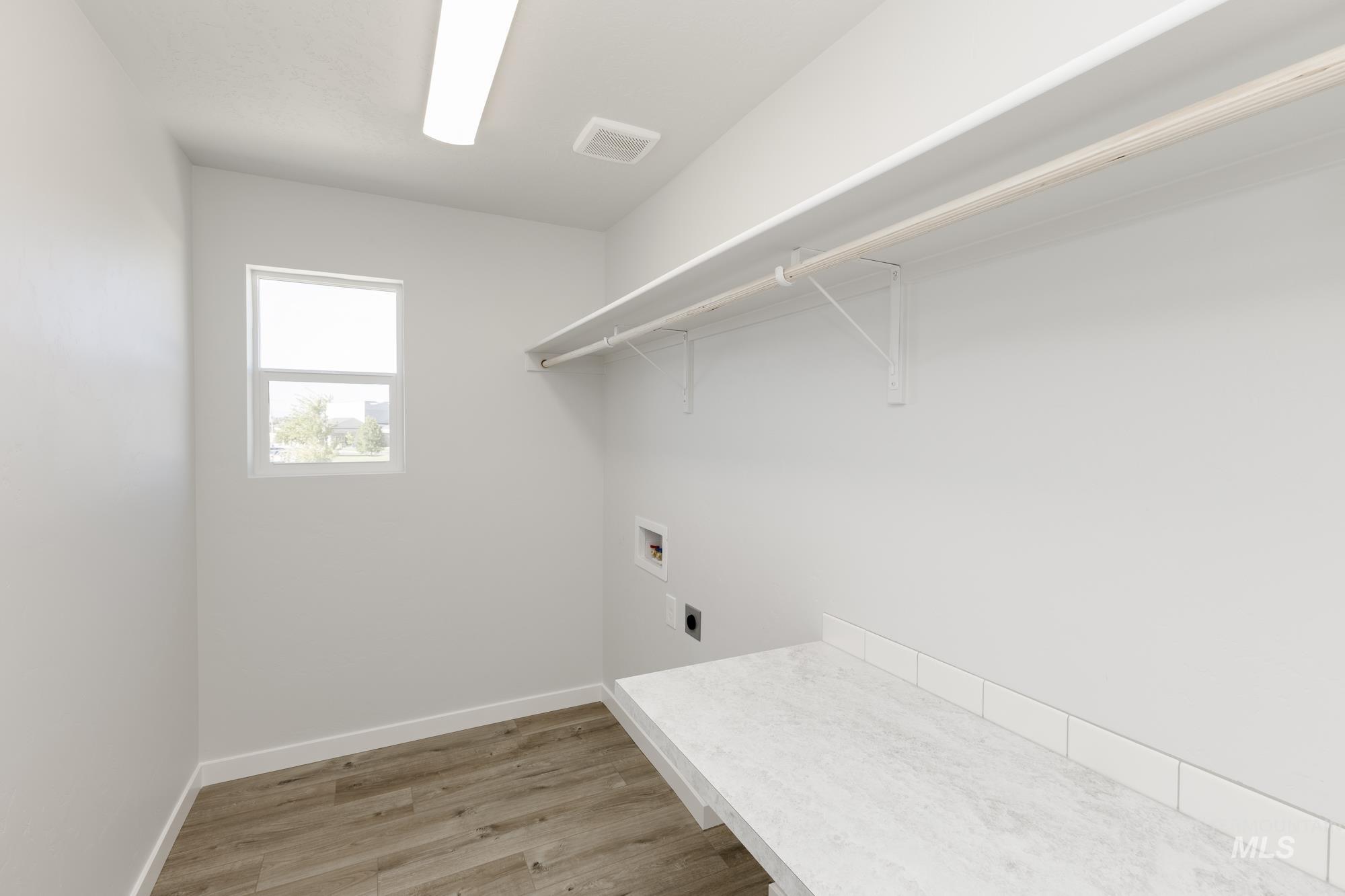 Laundry room featuring light wood-type flooring, washer hookup, and electric dryer hookup