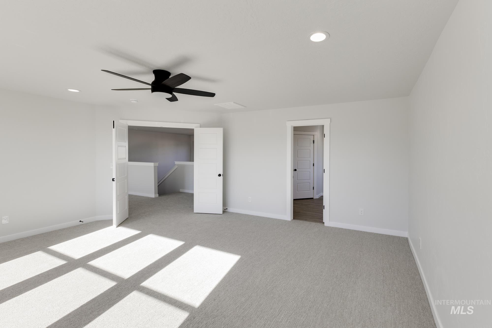 Unfurnished bedroom featuring light colored carpet, a ceiling fan, and recessed lighting