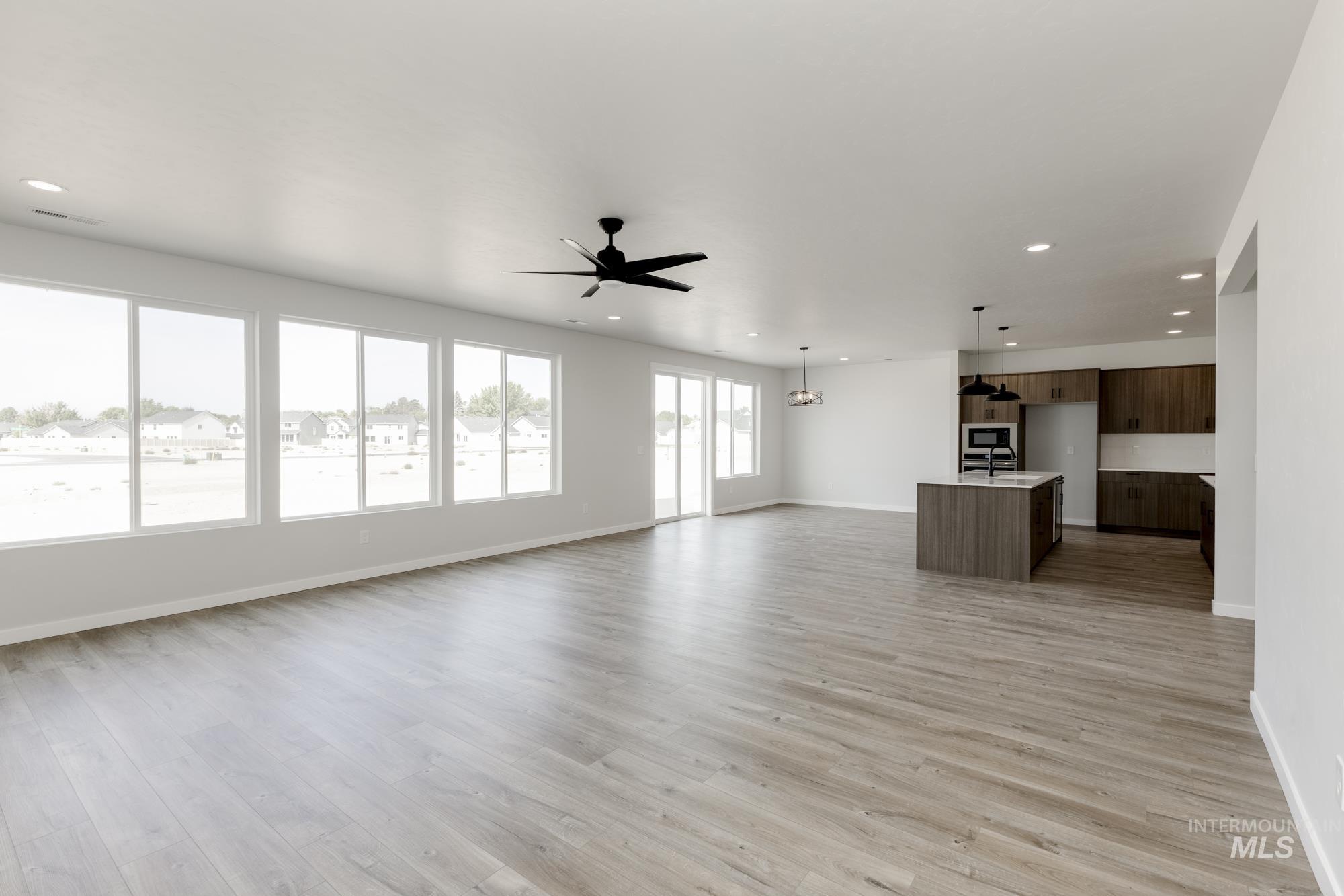 Unfurnished living room featuring light wood-style floors, recessed lighting, and a ceiling fan