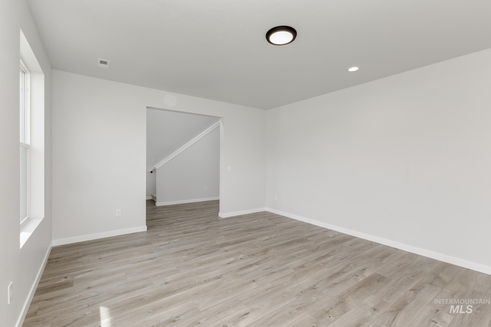 Unfurnished room with light wood-type flooring and recessed lighting
