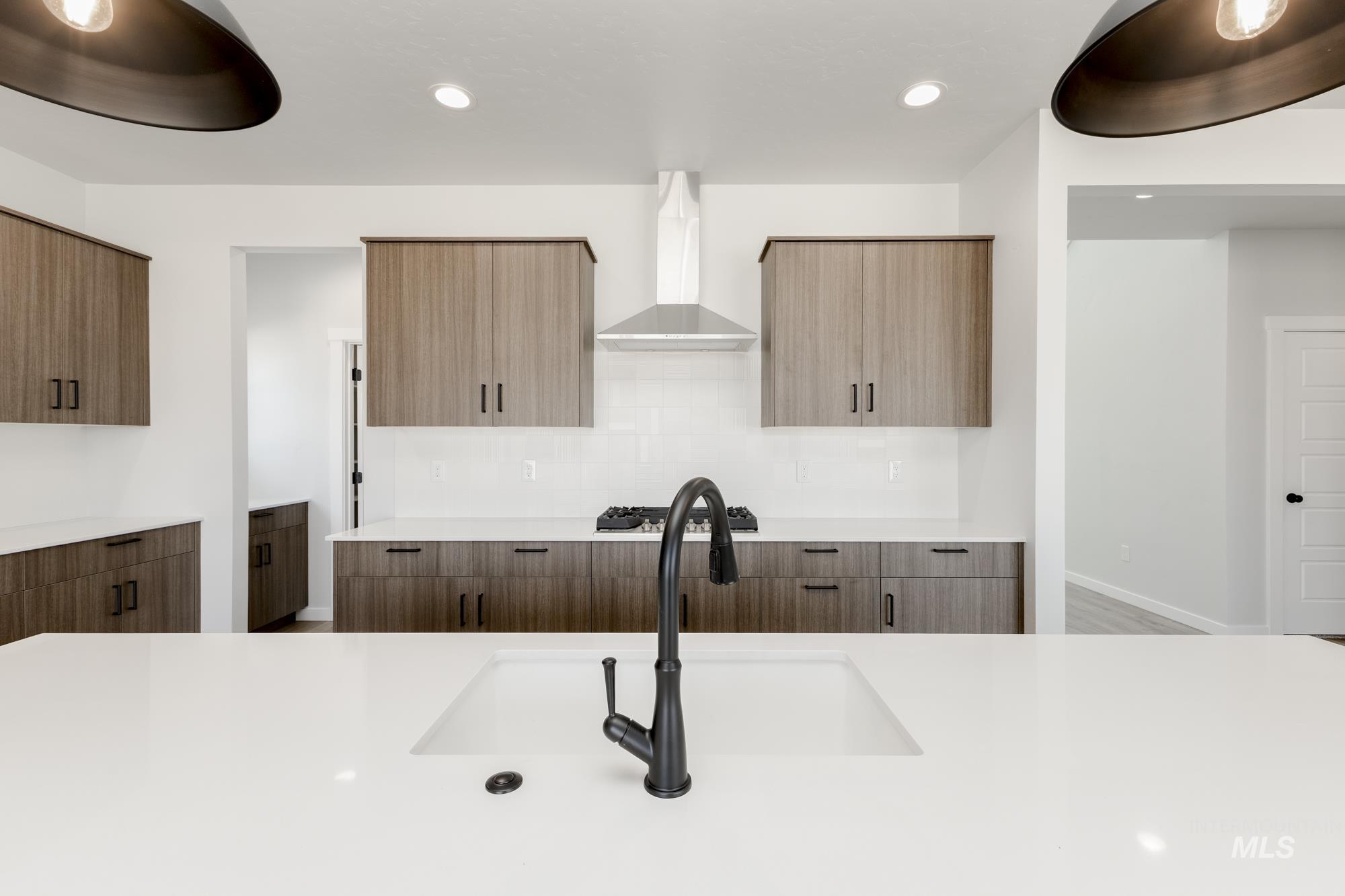 Kitchen with modern cabinets, wall chimney range hood, backsplash, and recessed lighting