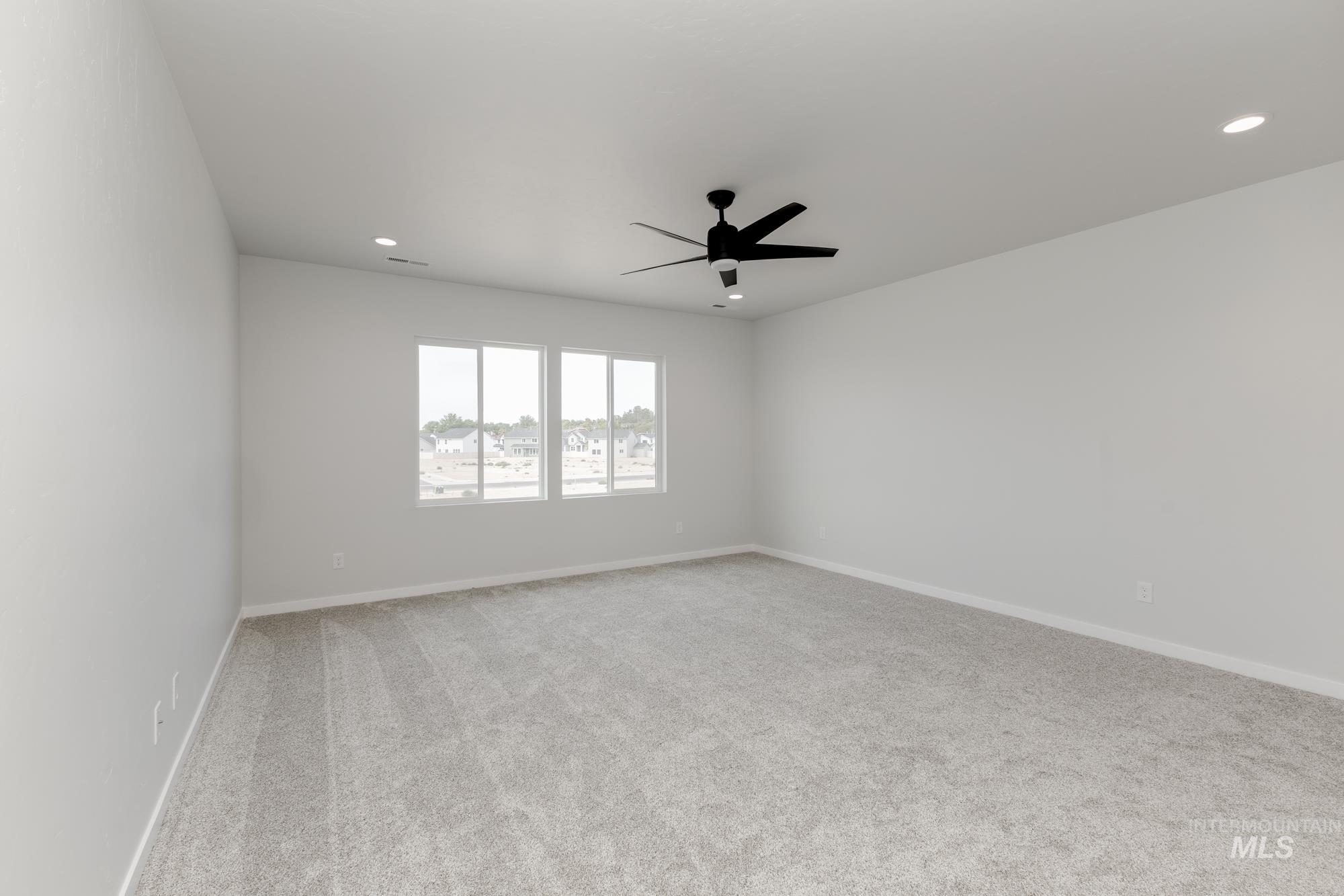 Empty room featuring light carpet, recessed lighting, and a ceiling fan