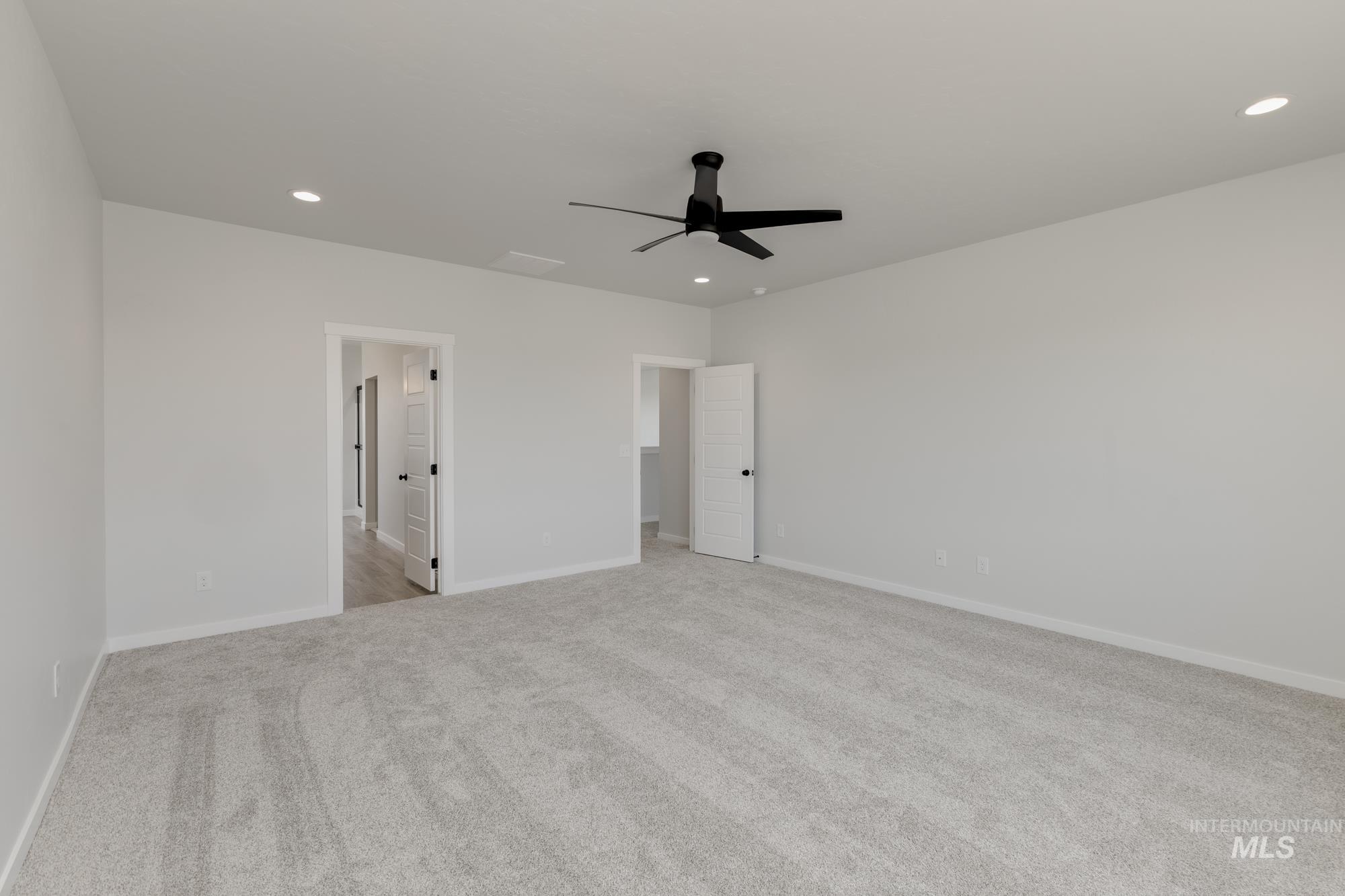 Unfurnished bedroom with light colored carpet, a ceiling fan, and recessed lighting